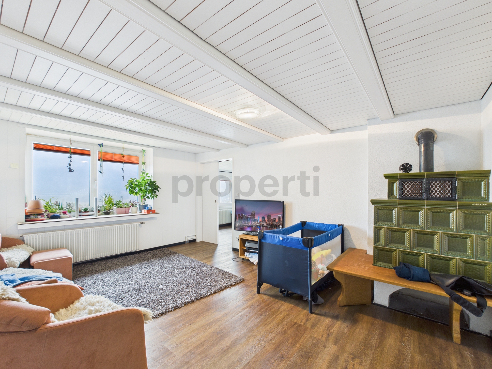 Helles Wohnzimmer mit Ofen und Fensternische