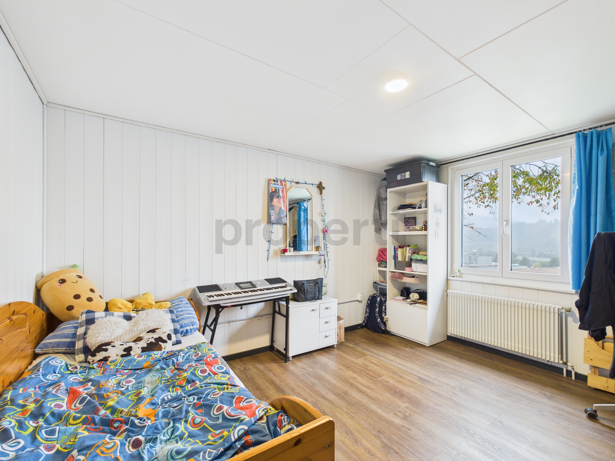 Jugendliches Schlafzimmer mit Bett und Fenster