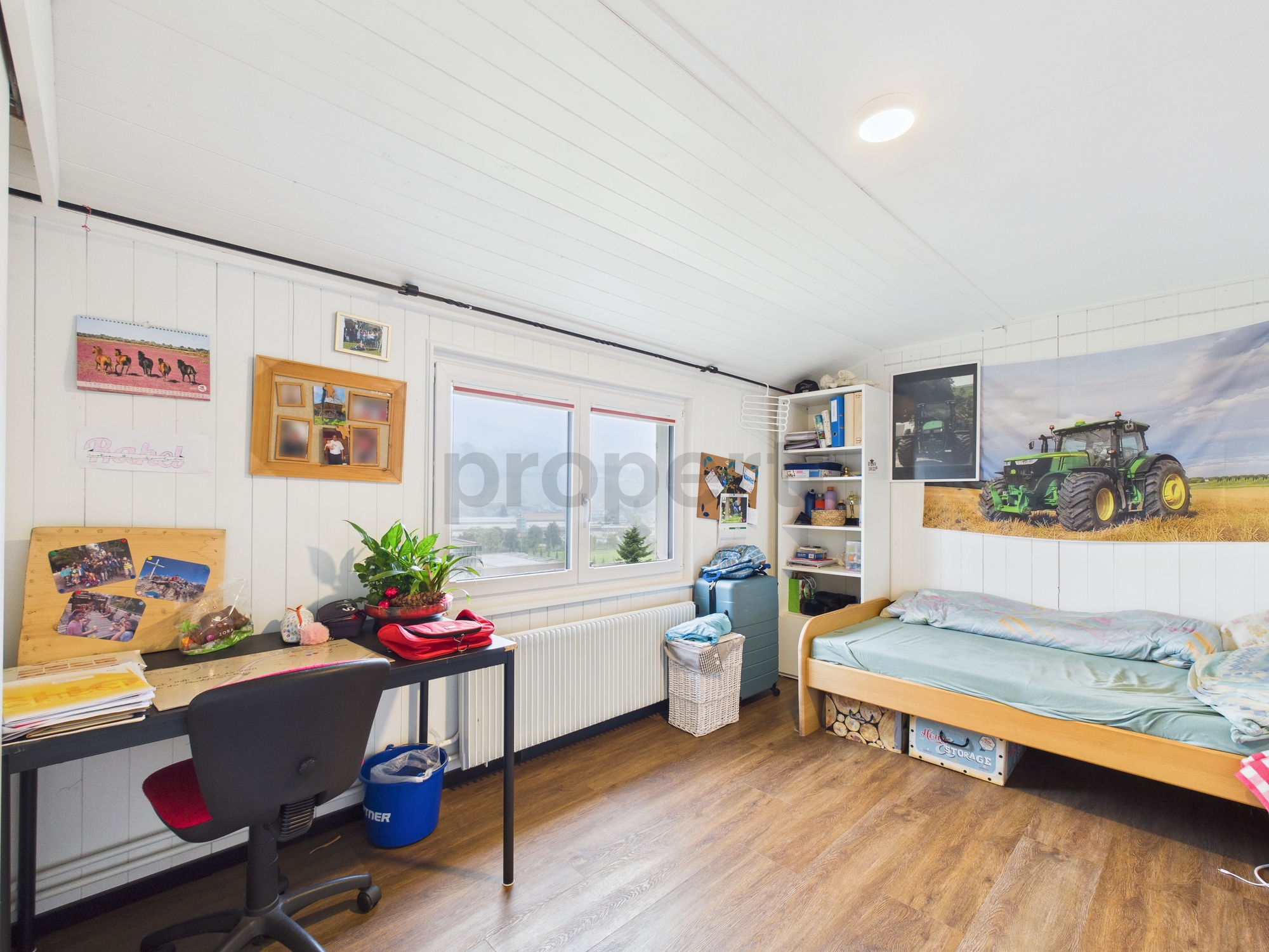 Jugendzimmer mit Schreibtisch und Bett