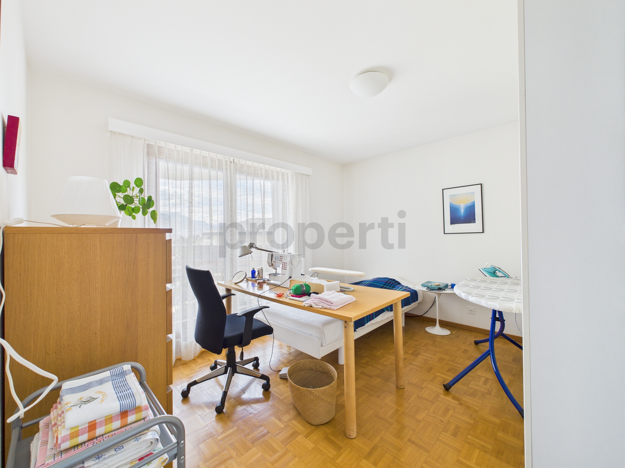 Helles, schlichtes Schlafzimmer mit Arbeitsbereich