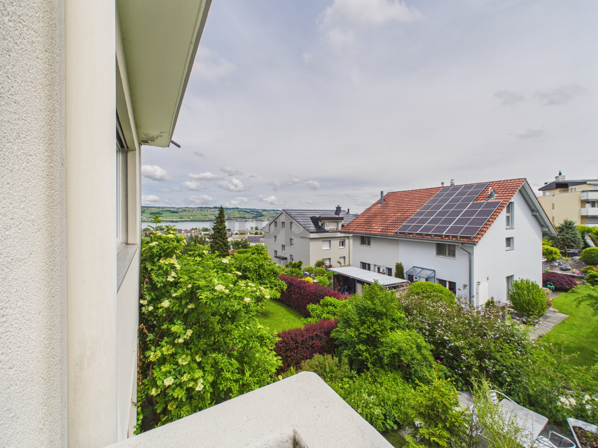 Blick vom Fenster auf Wohngebiet und Garten