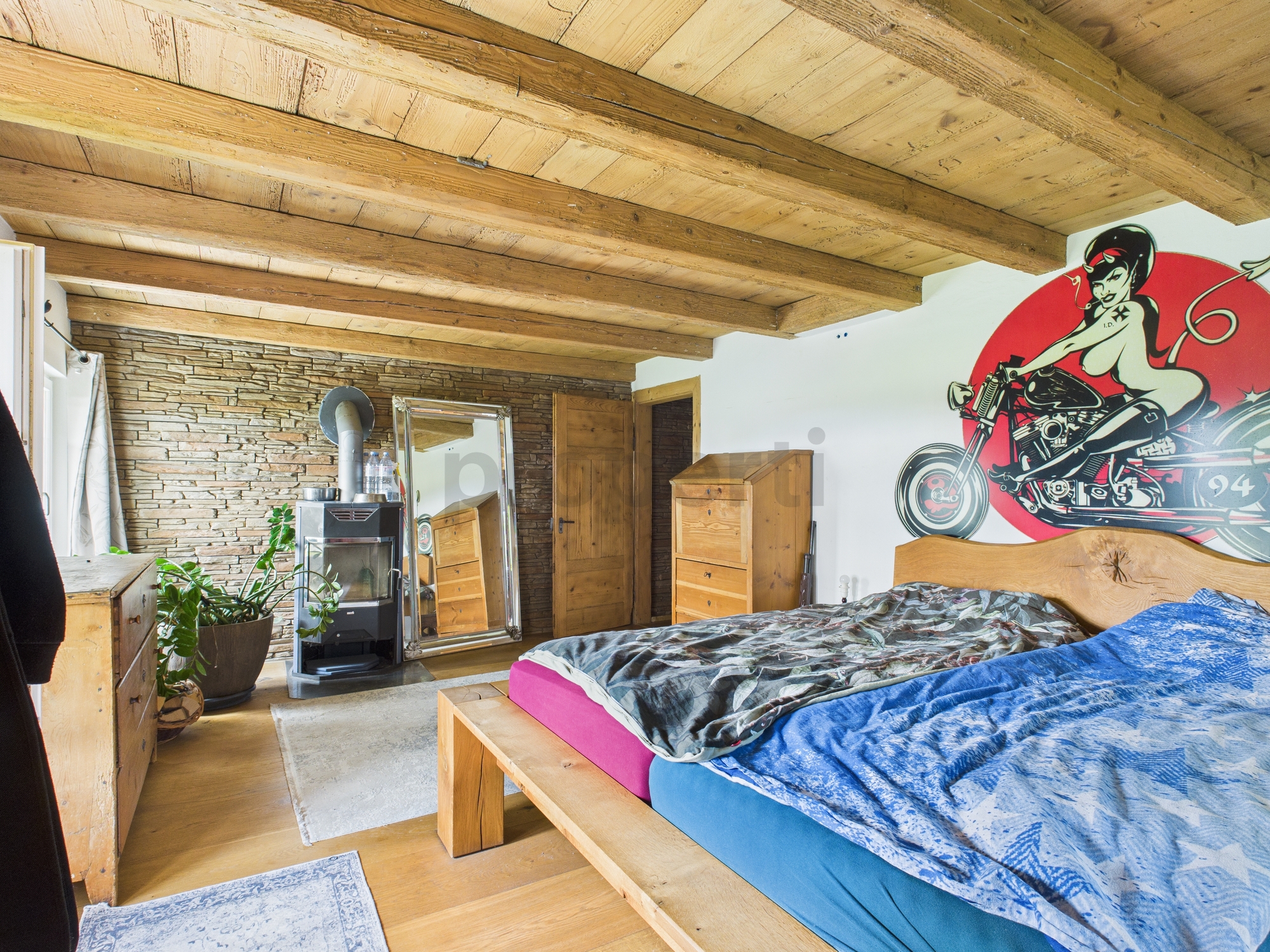 Rustikal eingerichtetes Schlafzimmer mit Holzbalkendecke