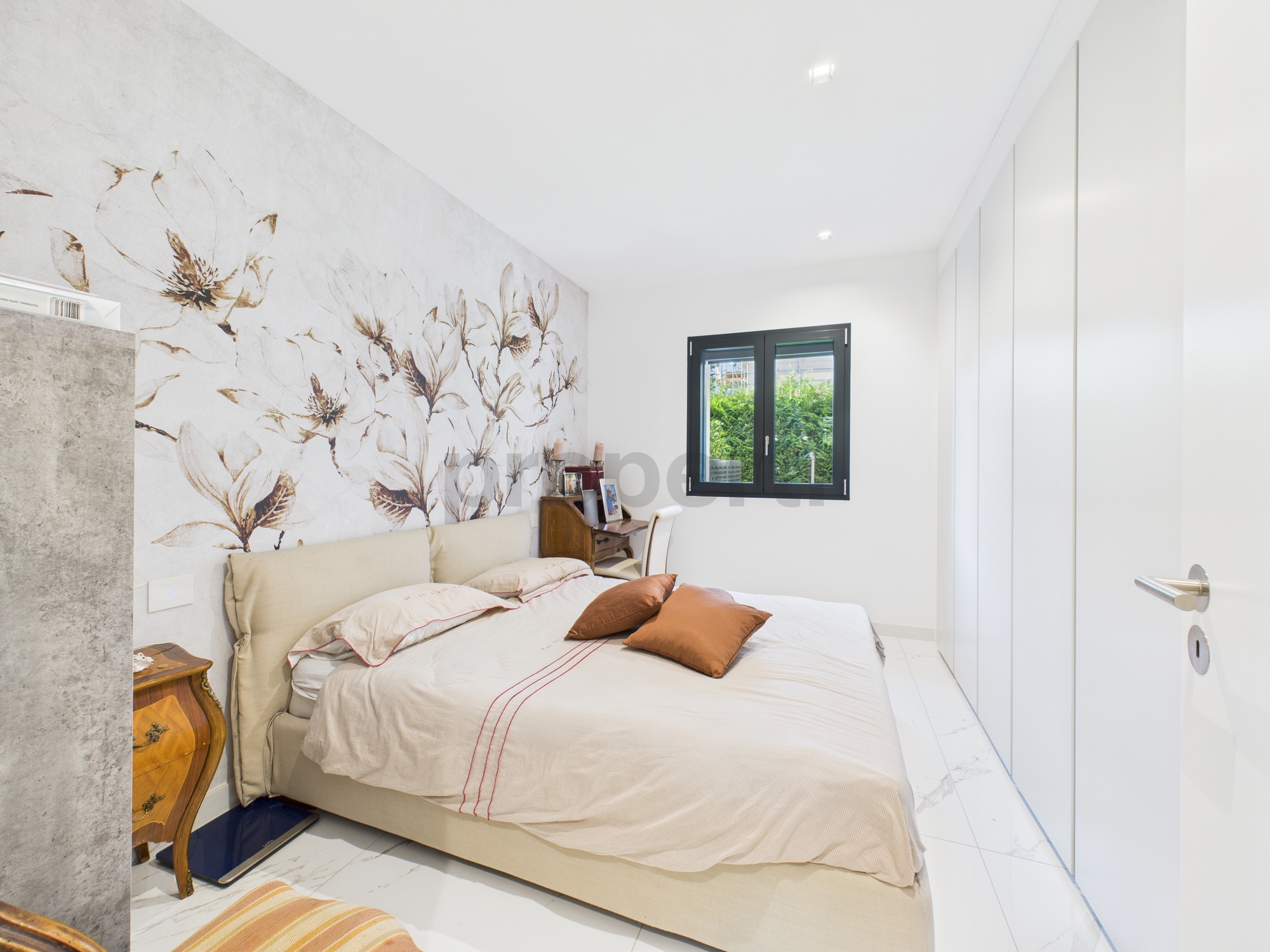 Helles Schlafzimmer mit floralem Akzent und moderner Ausstattung