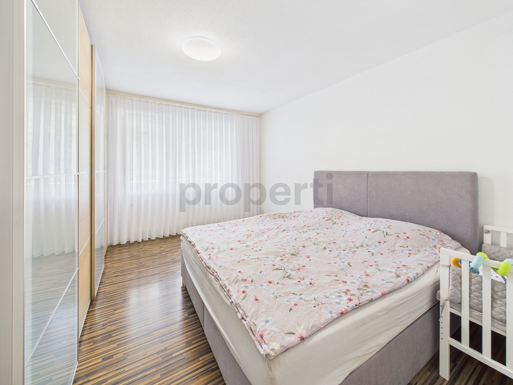 Helles Schlafzimmer mit großem Bett und Kleiderschrank