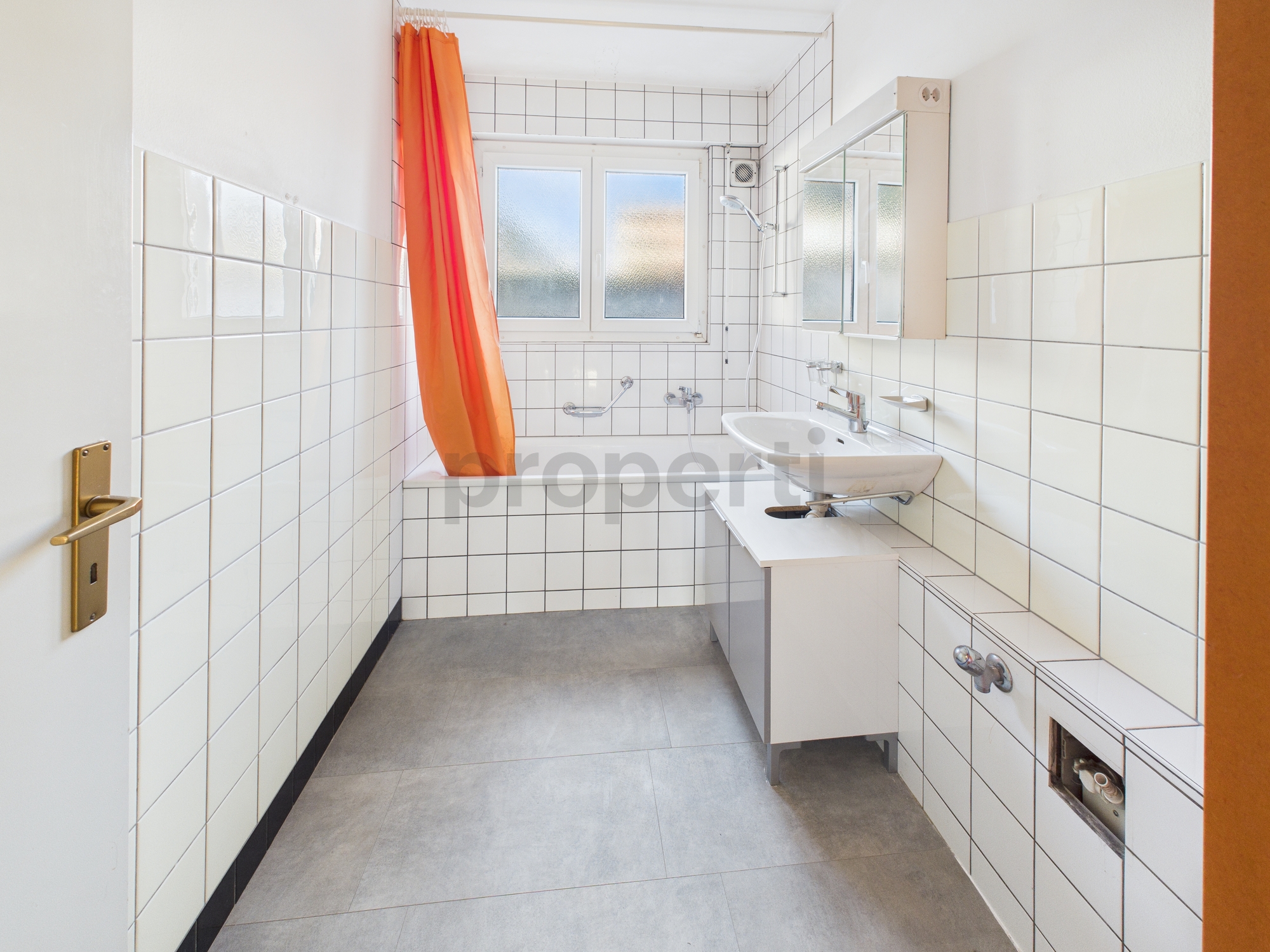 Kleines Badezimmer mit Badewanne und Fenster