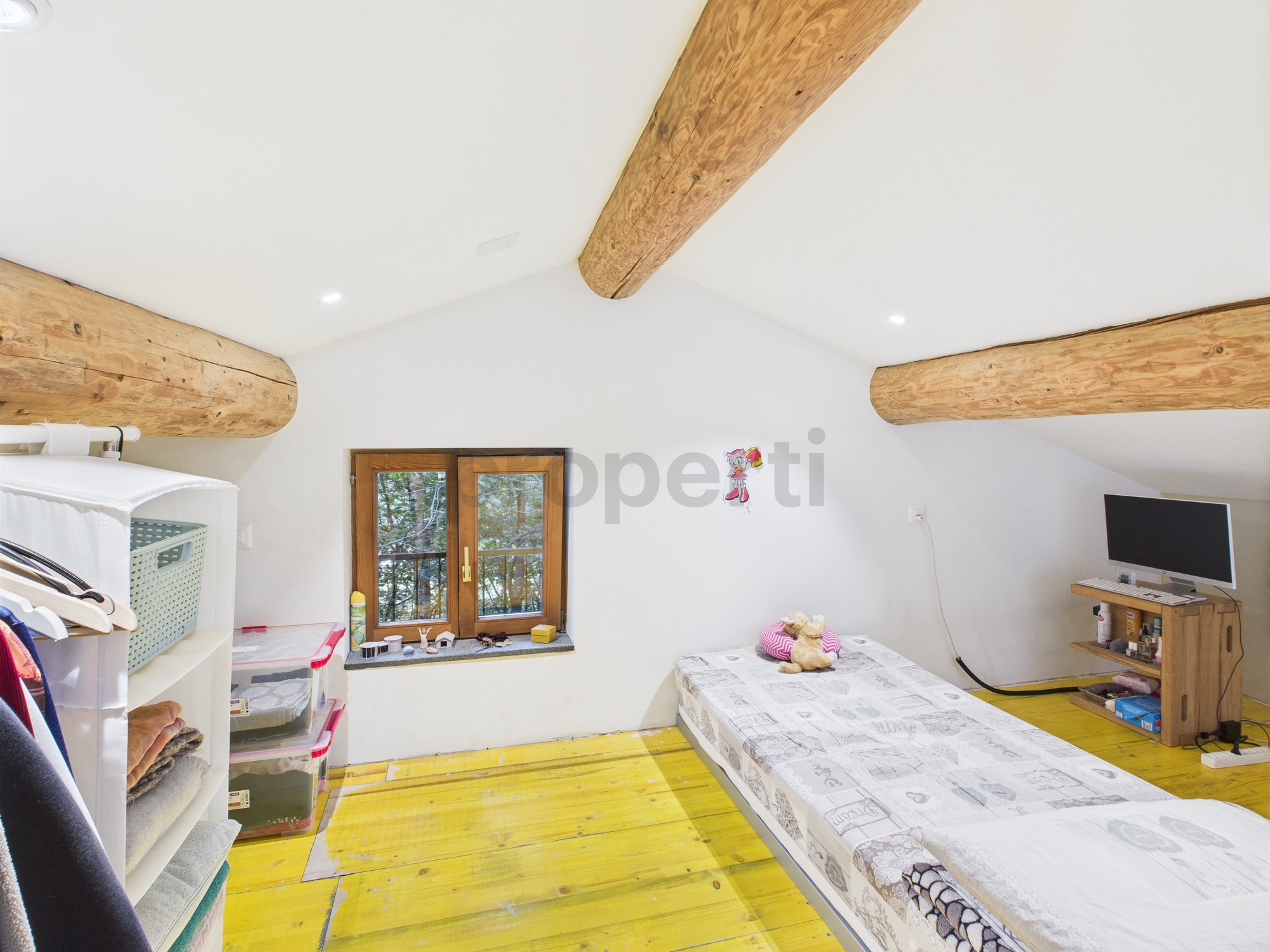 Dachzimmer mit sichtbaren Holzbalken