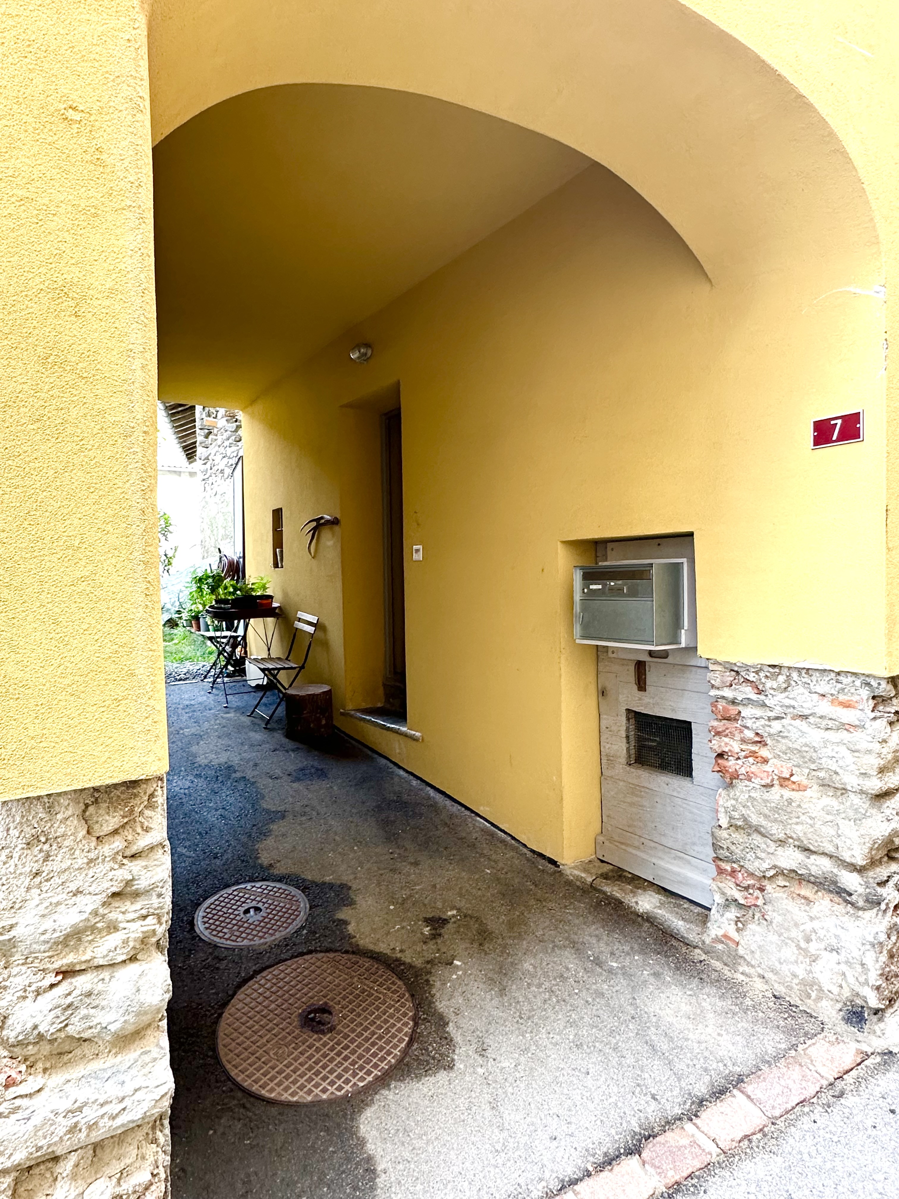 Überdachter Hauseingang mit gelber Fassade