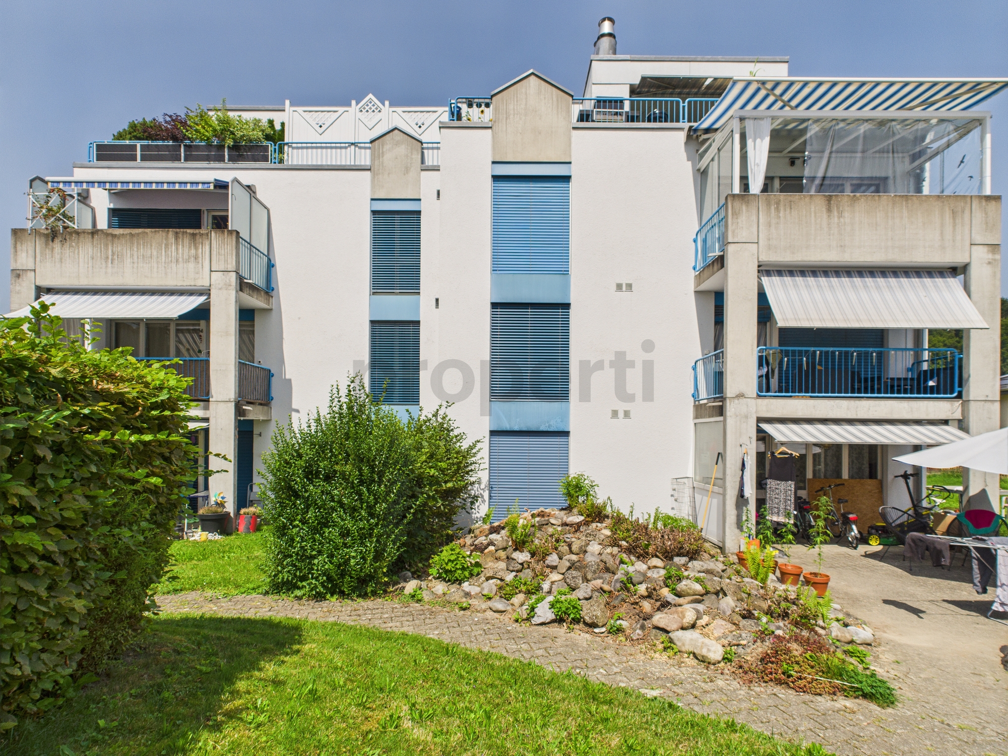 Mehrstöckiges Wohngebäude mit Balkonen und Garten