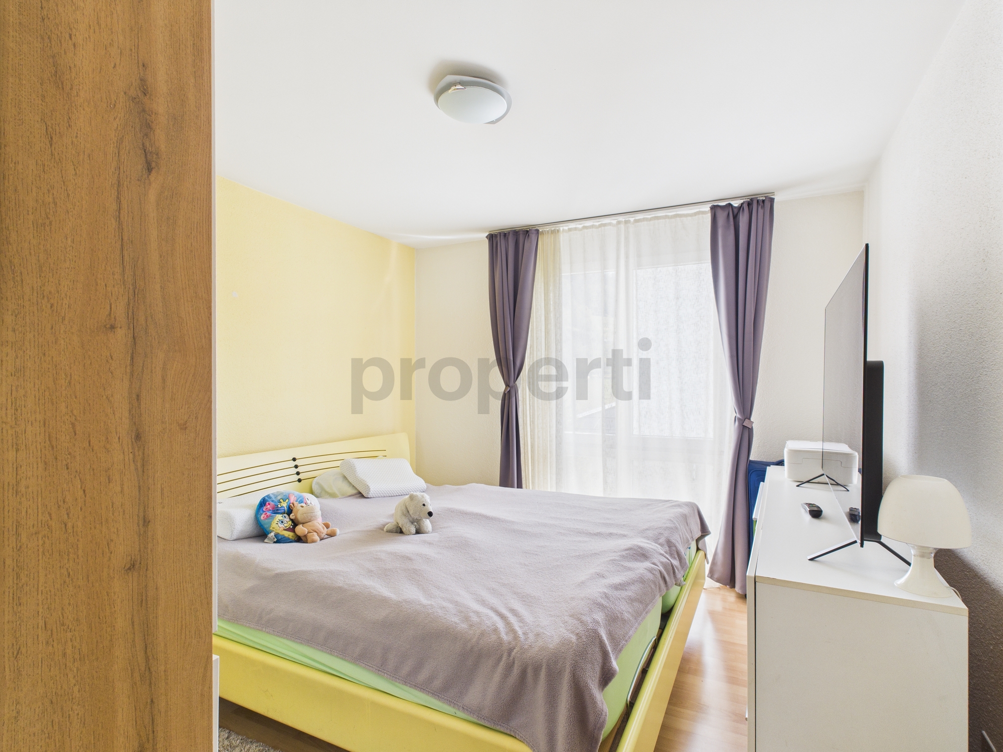 Helles Schlafzimmer mit Kinderbett und Schrank