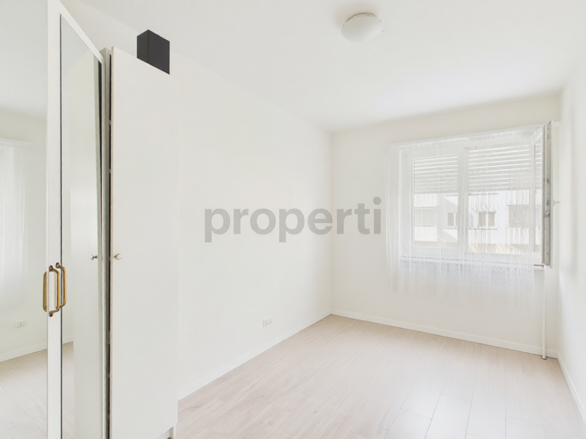 Helles, leerstehendes Schlafzimmer mit Einbauschrank und Fenster