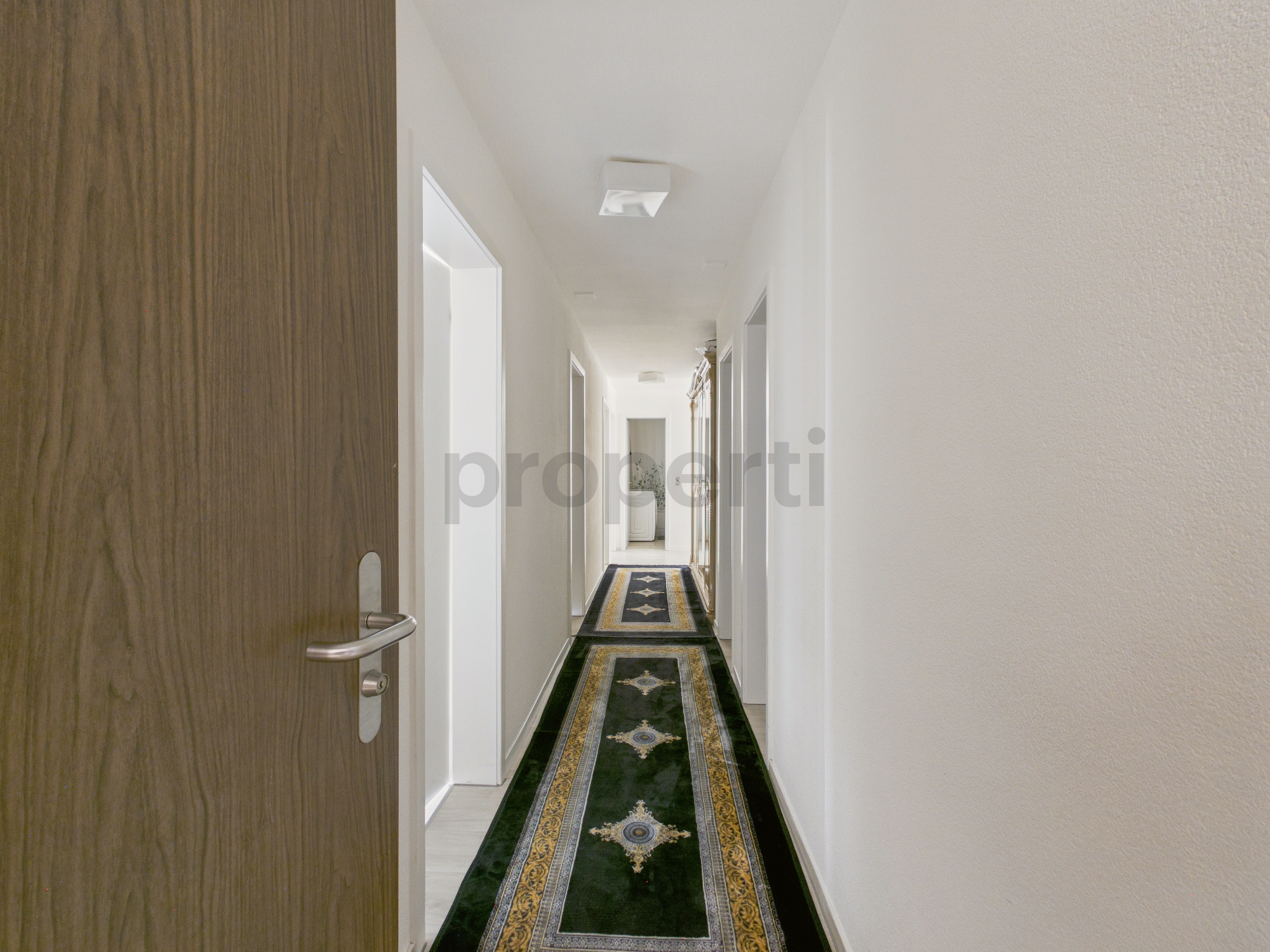 Langer Flur mit Teppichläufern