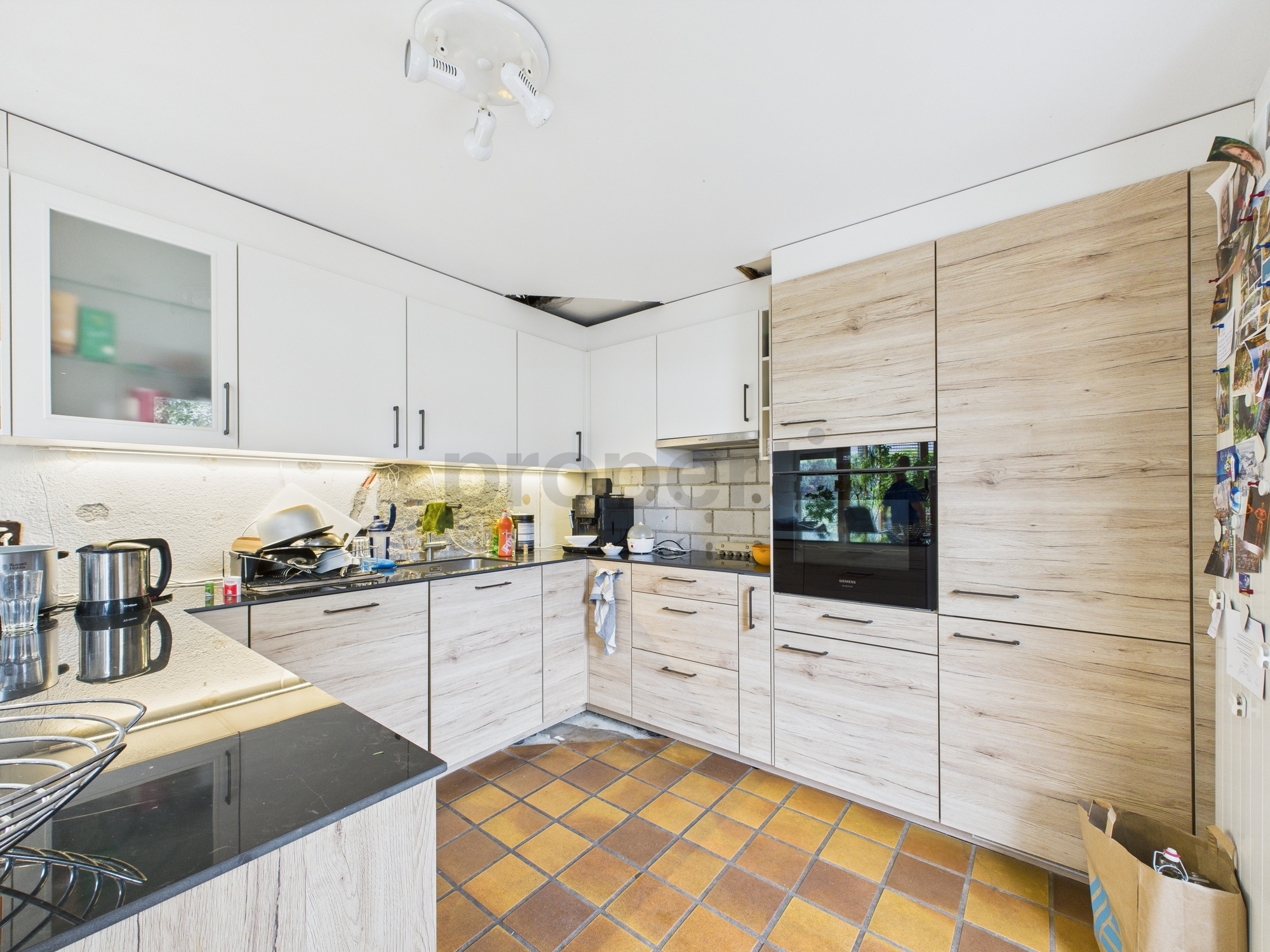 Moderne Einbauküche mit Holzoptik und schwarzen Arbeitsflächen