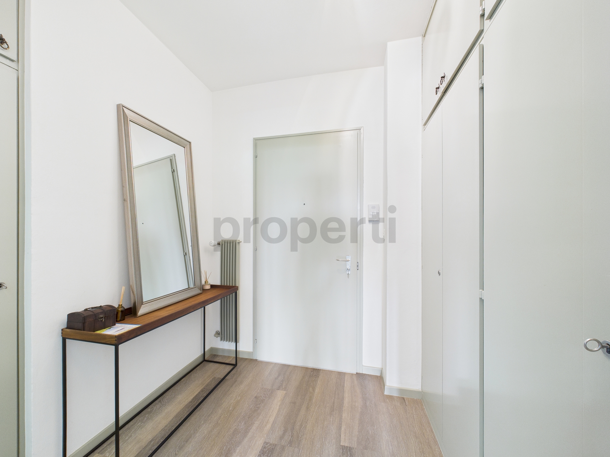 Heller Eingangsbereich mit Spiegel und Garderobe