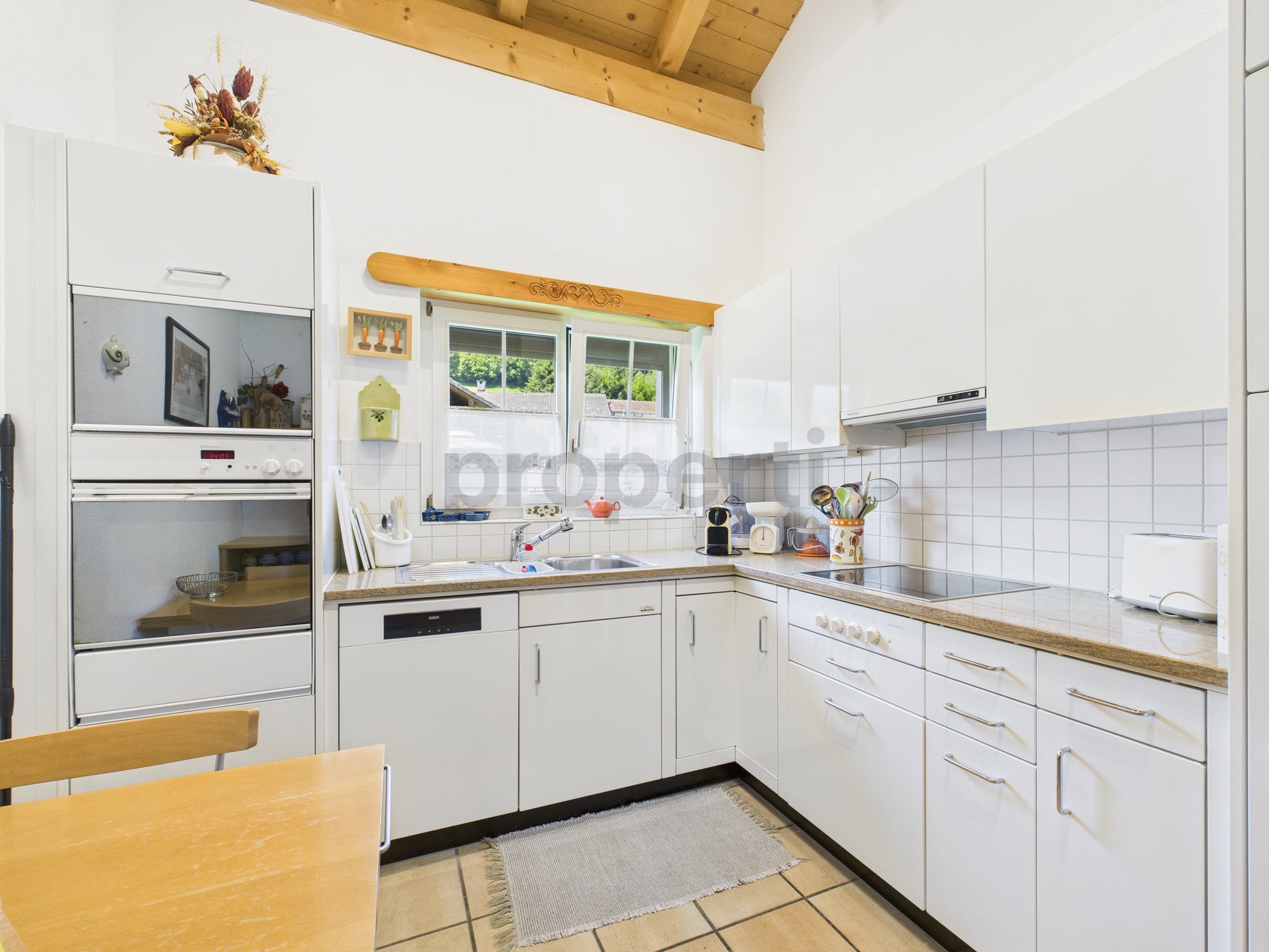 Helle U-förmige Küche mit Holzdecke
