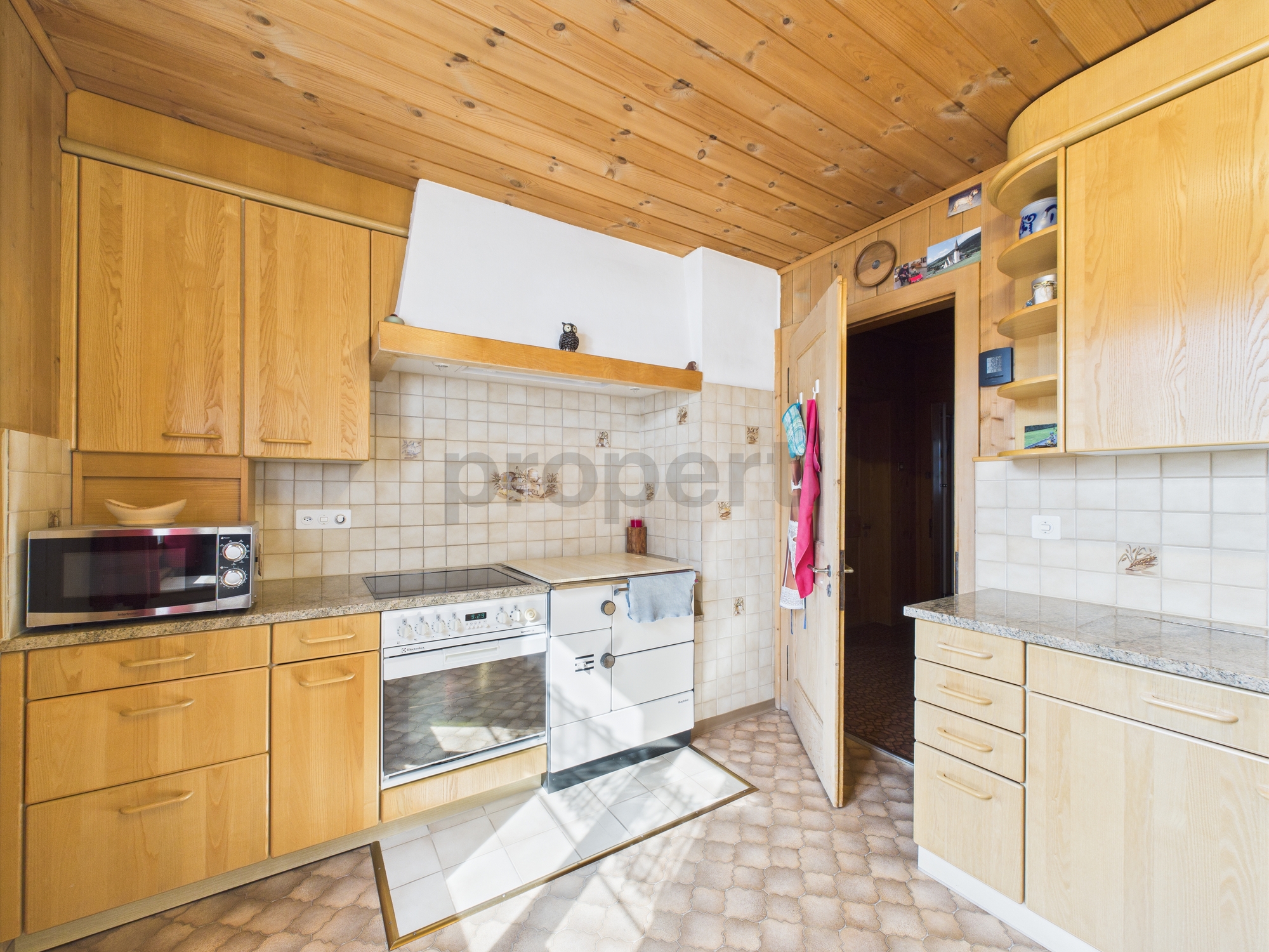 Helle Landhausküche mit Holzvertäfelung