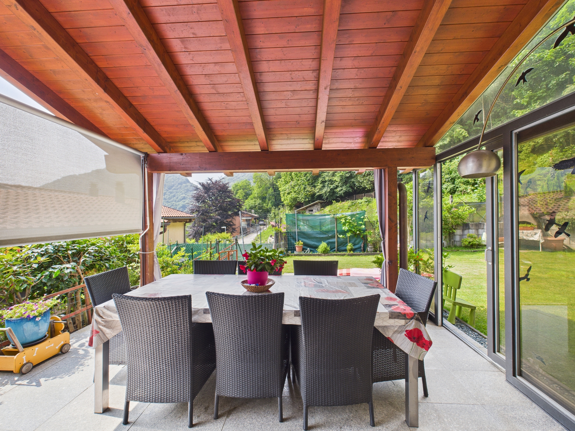 Überdachte Terrasse mit Essbereich und Gartenblick