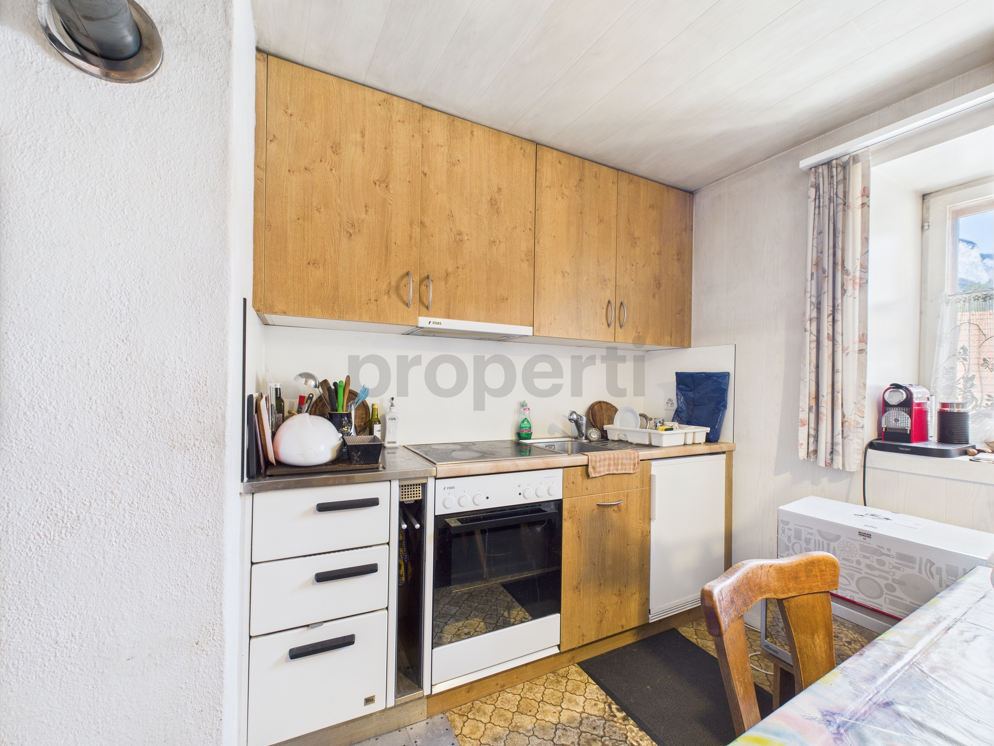 Kleine Küche mit Holzfronten und Fenster