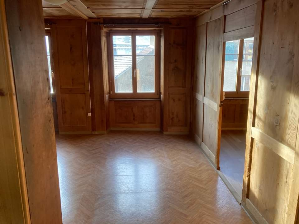 Holzvertäfelter Raum mit drei Fenstern