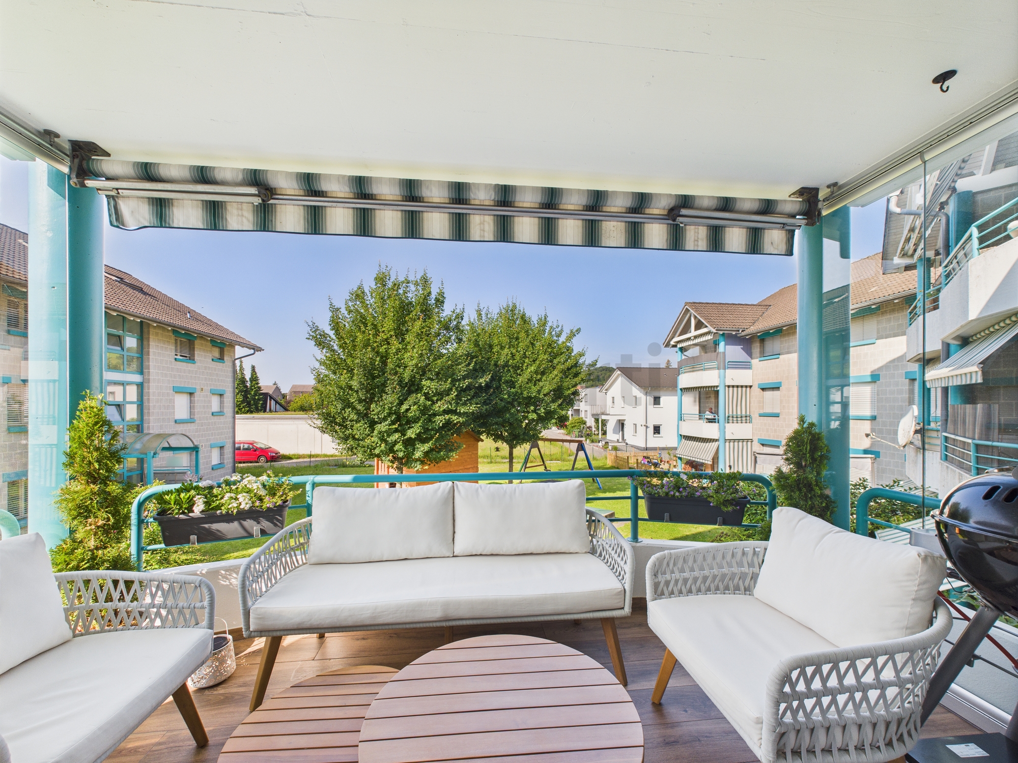 Balkon mit Sitzgruppe und Blick auf Wohnanlage