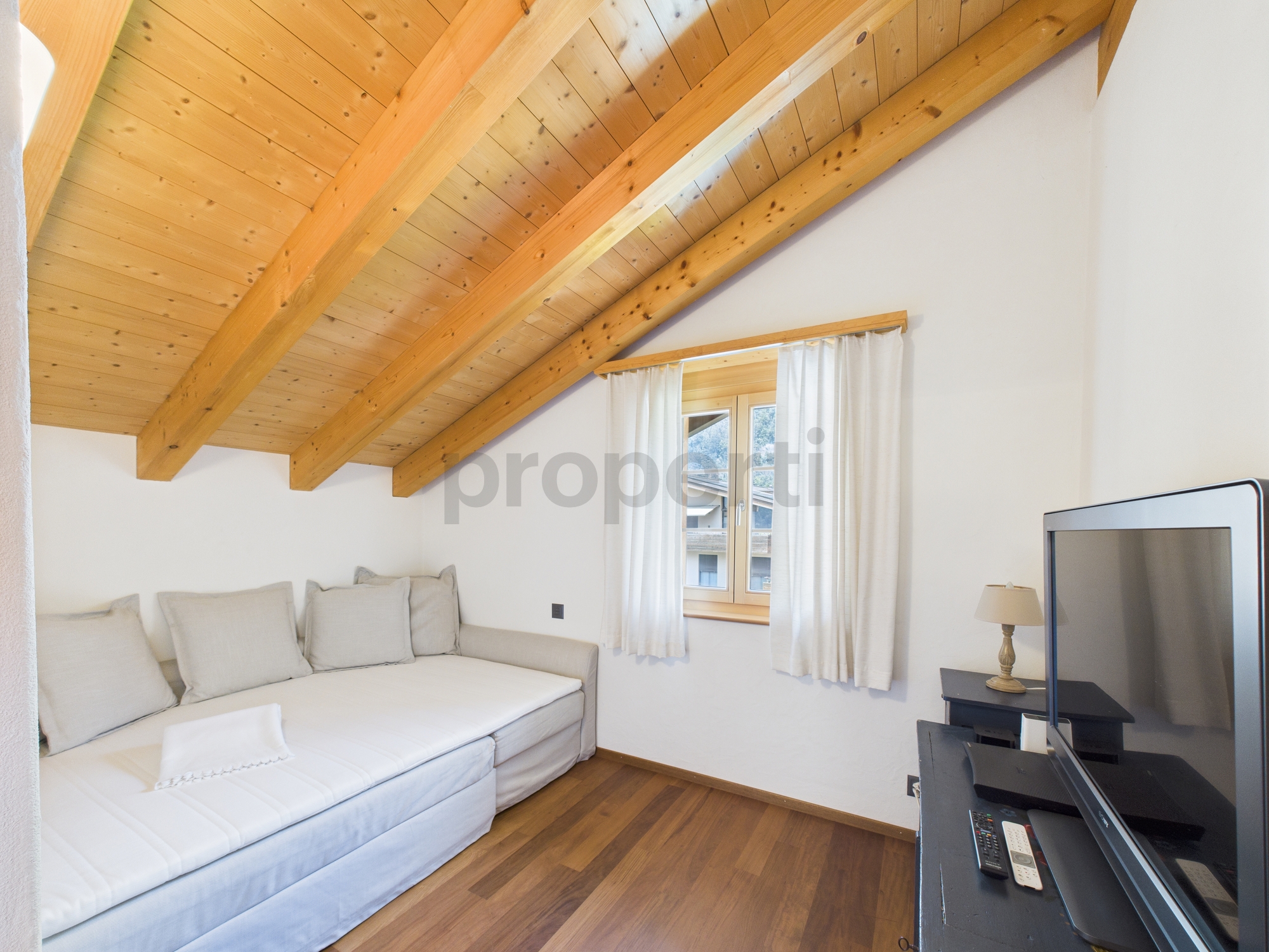 Helles Dachzimmer mit sichtbaren Holzbalken