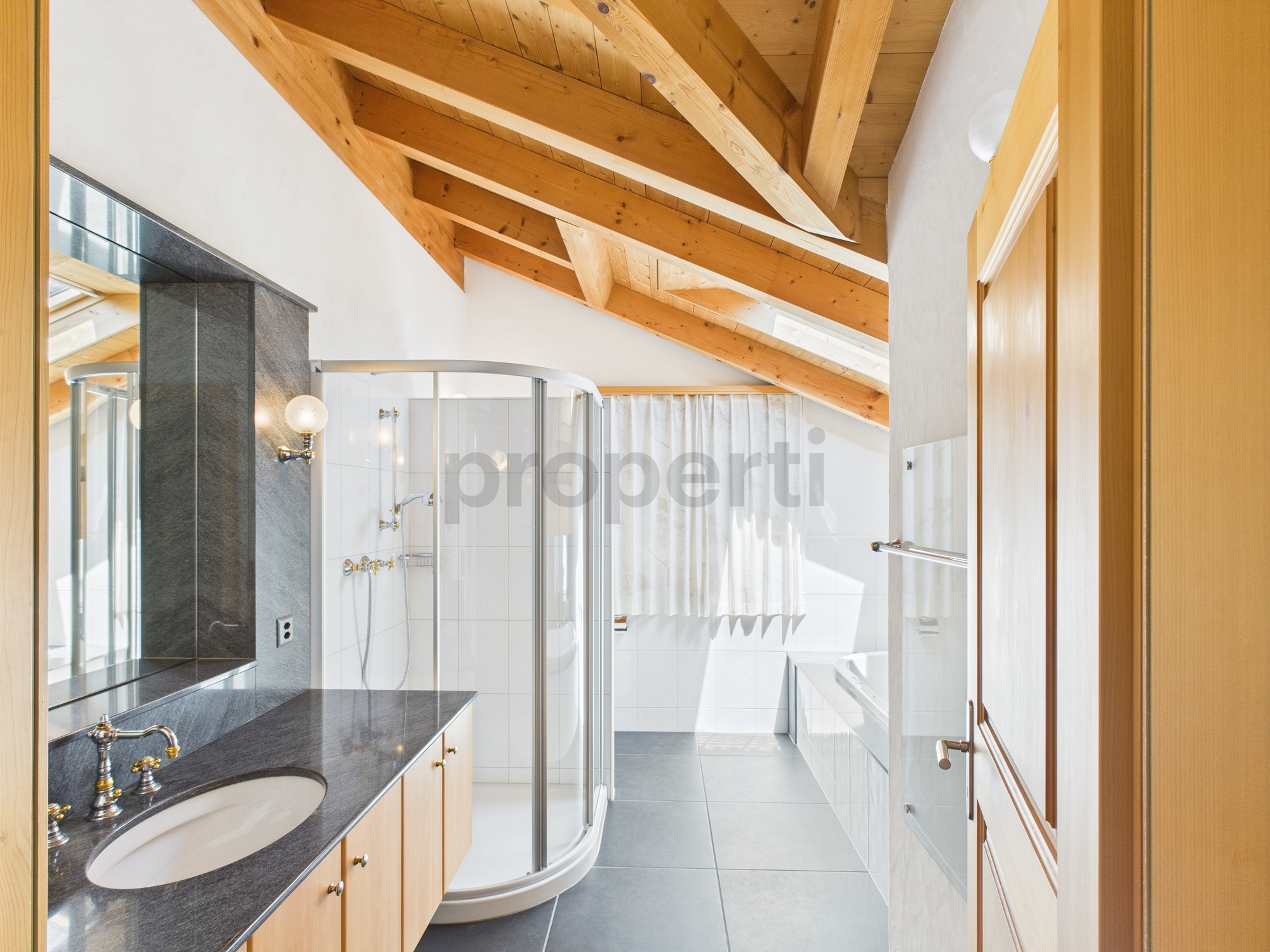 Dachgeschossbad mit Holzbalken und Eckdusche