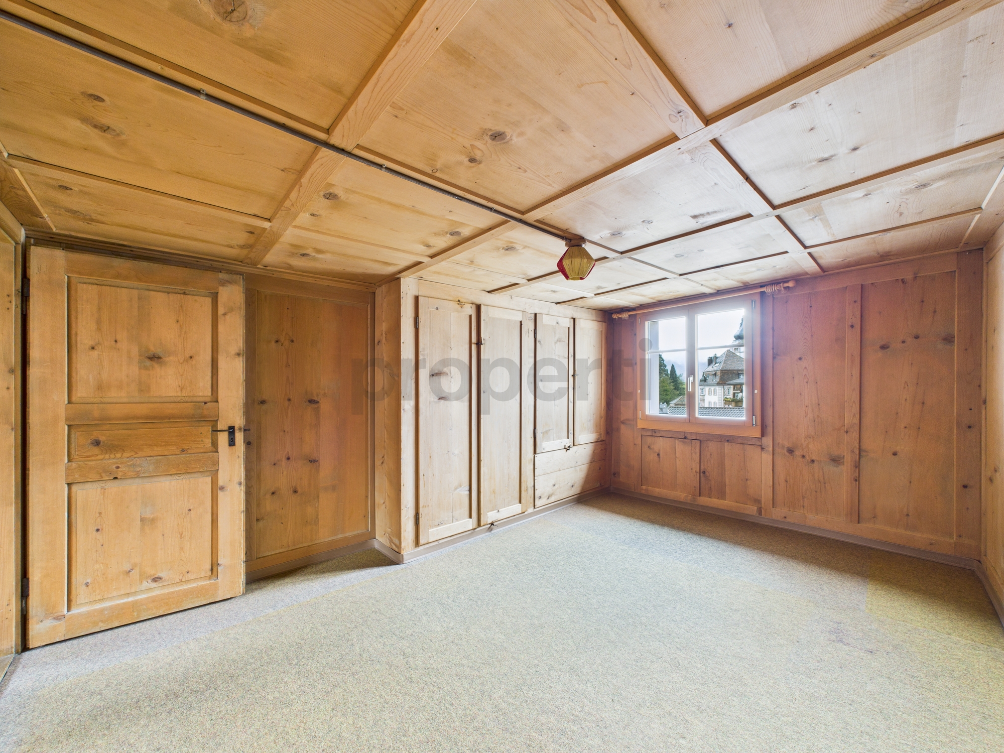 Rustikales Holzzimmer mit Fenster und Einbauschränken
