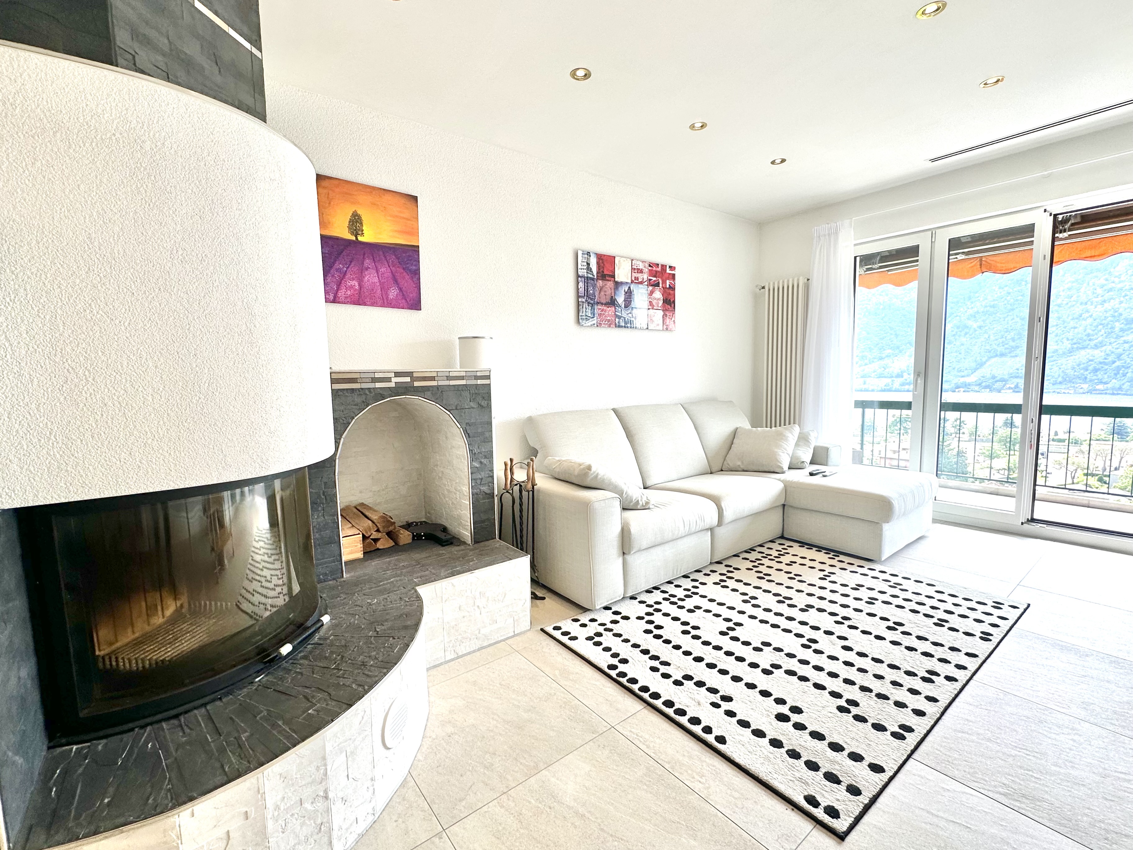 Heller Wohnraum mit Kamin und Balkonblick
