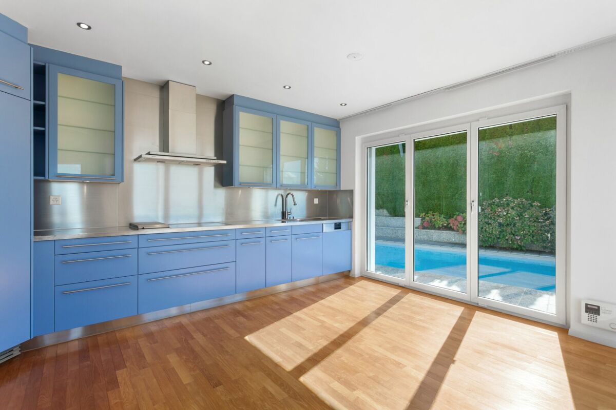 Blaue Küche mit Blick auf den Pool