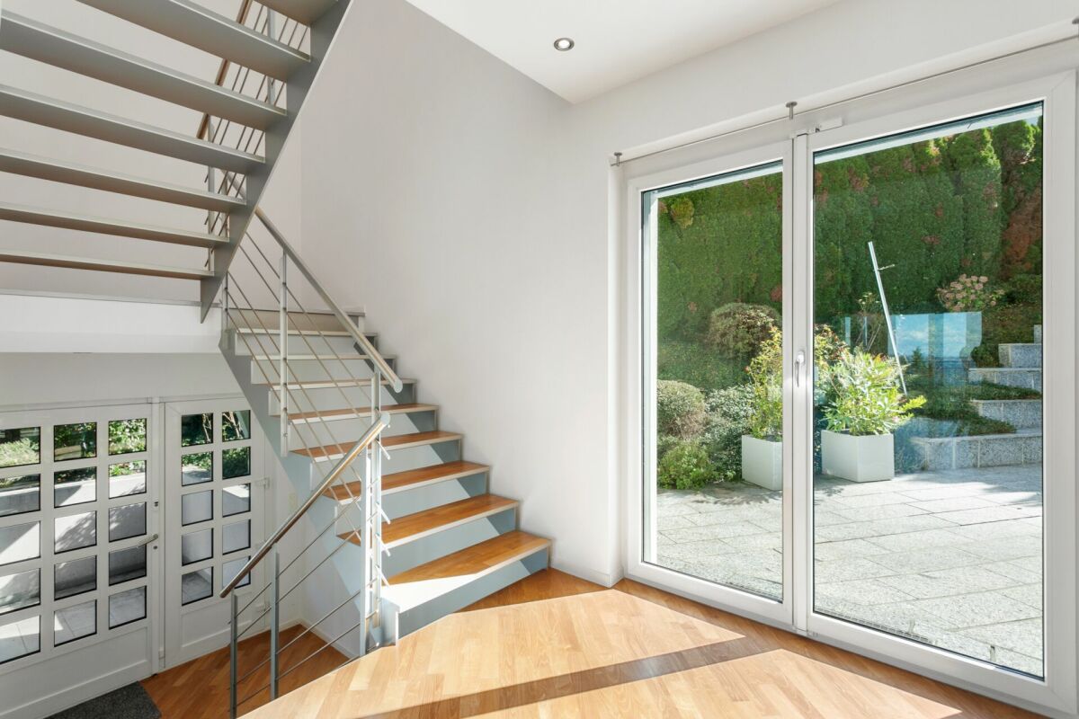 Heller Eingangsbereich mit Treppe und Gartenblick