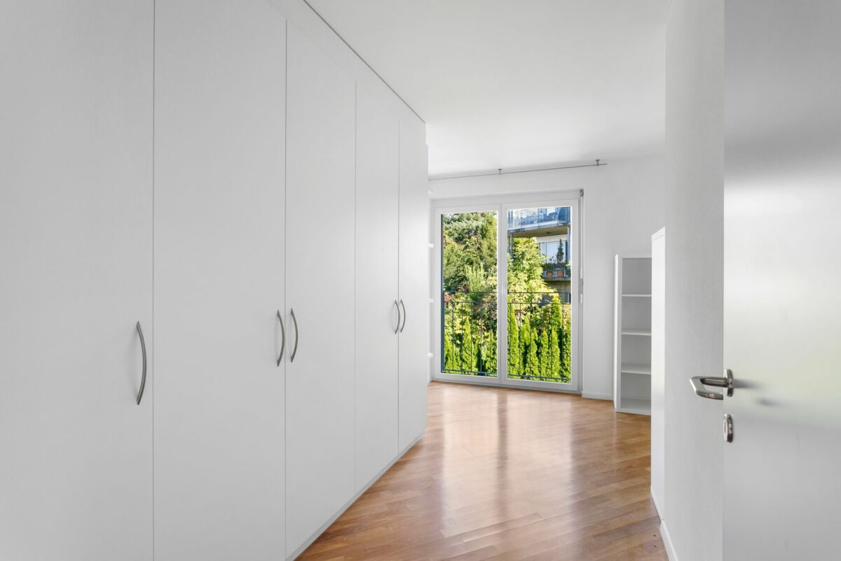 Helles Schlafzimmer mit Einbauschrank und Balkonblick