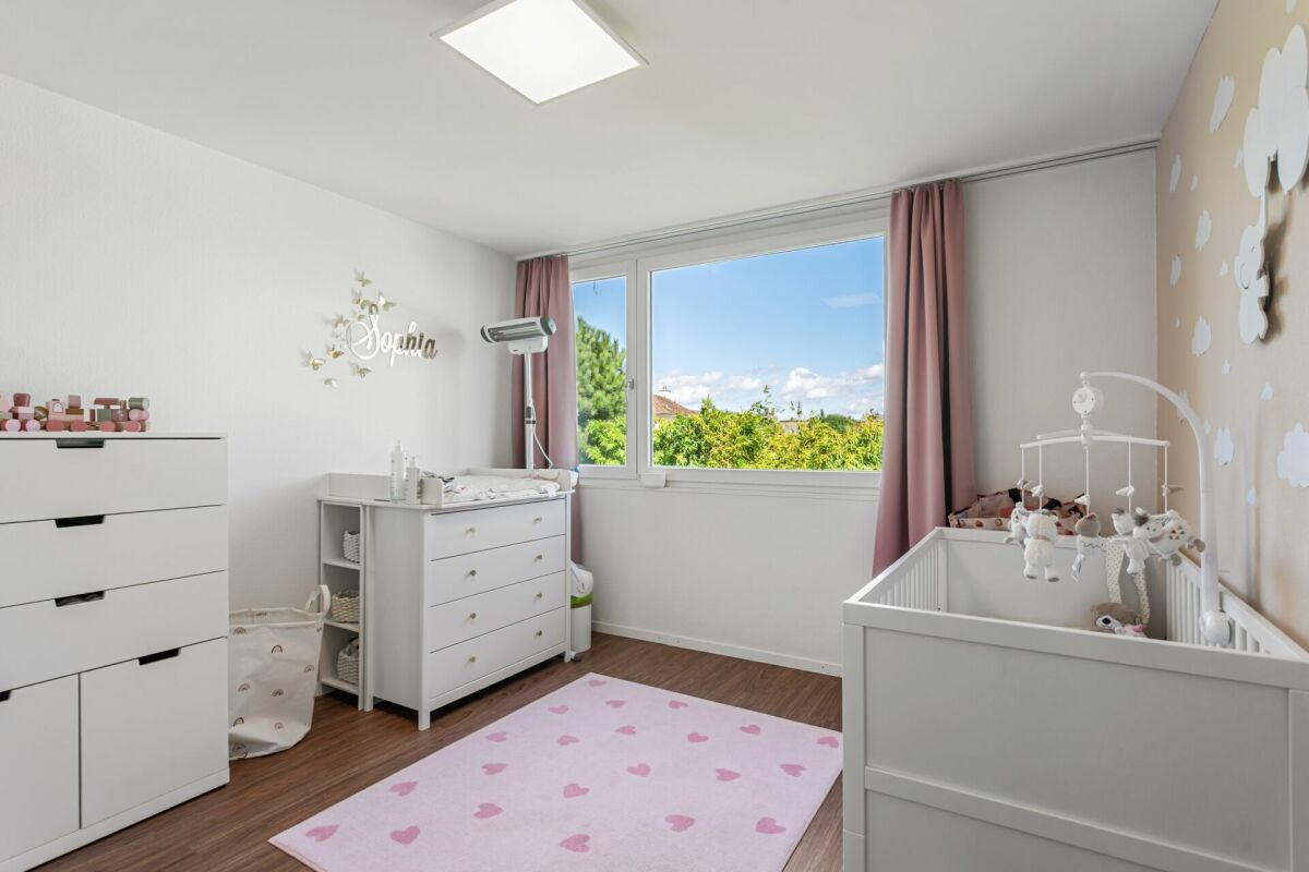Kinderzimmer mit weißen Möbeln und rosa Akzenten
