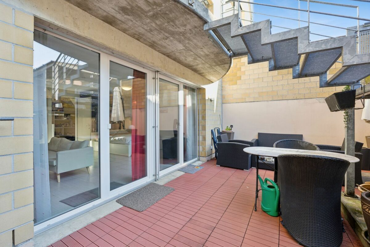 Terrasse mit Sitzgruppe unter Außentreppe