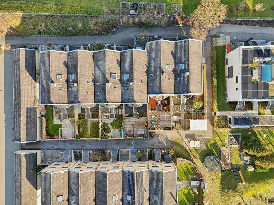Luftaufnahme einer Reihenhausanlage mit Gärten