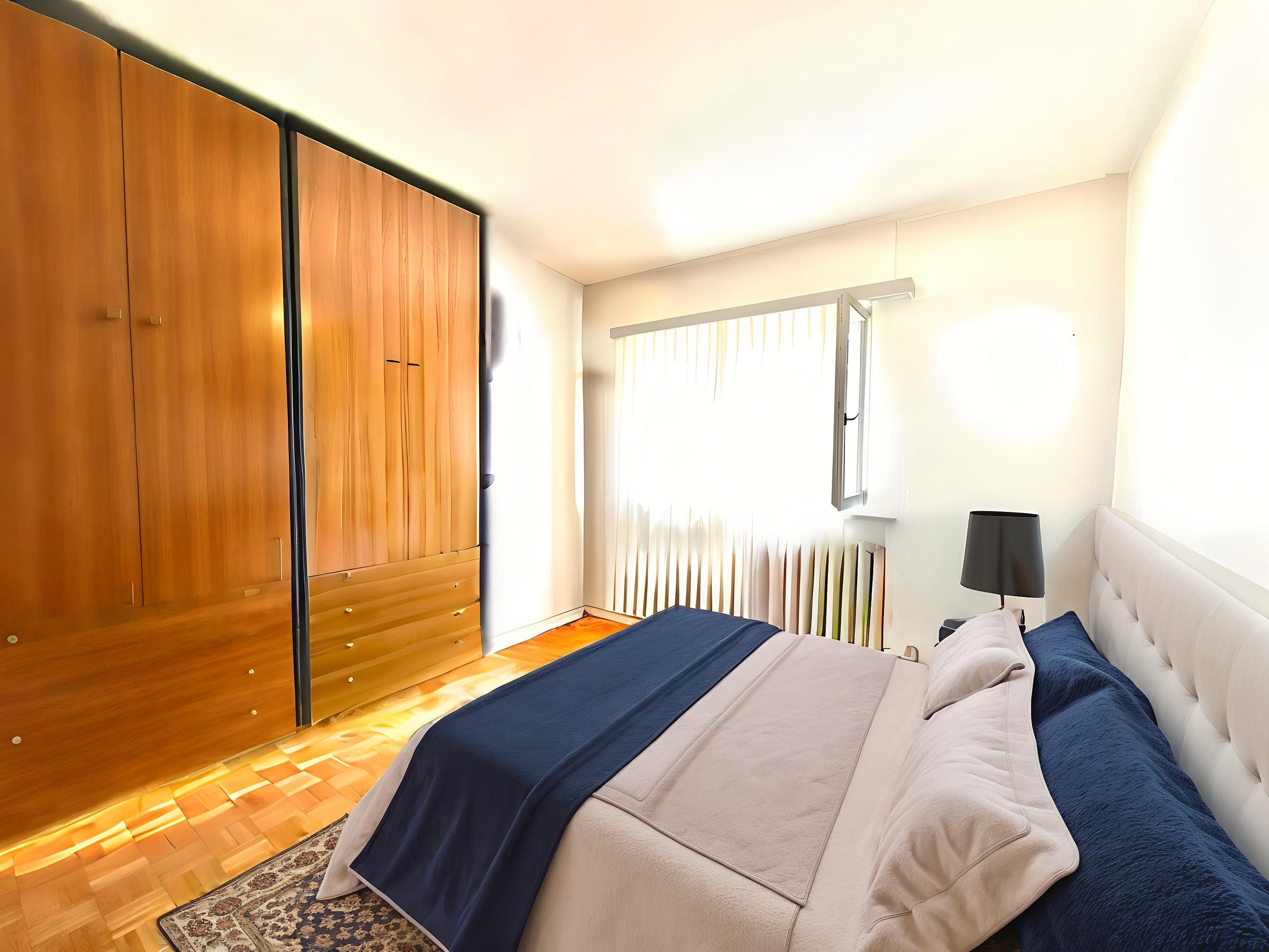 Helles Schlafzimmer mit Holzkleiderschrank und großem Bett
