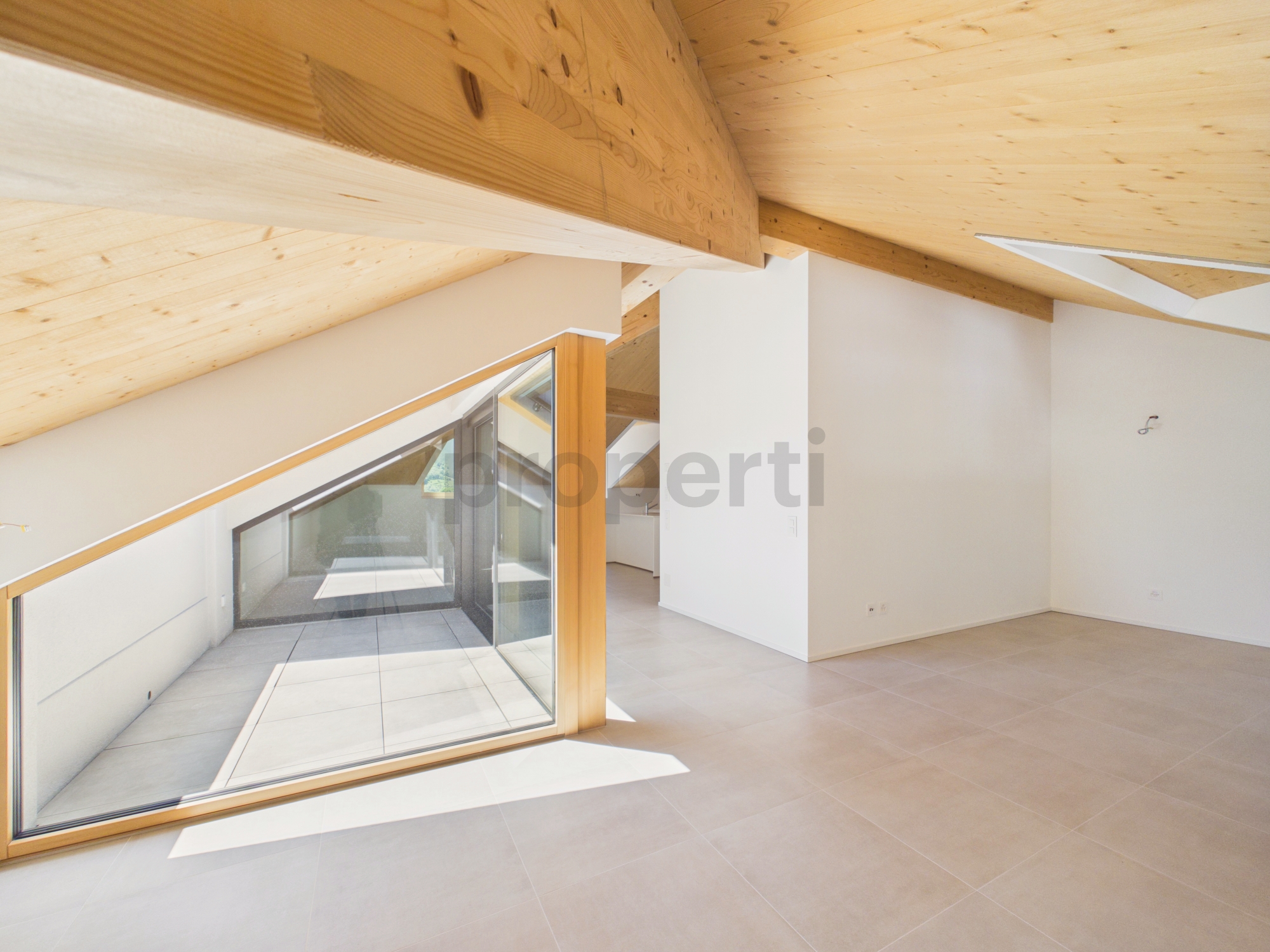 Heller Dachraum mit Holzdecke und großer Glasfront