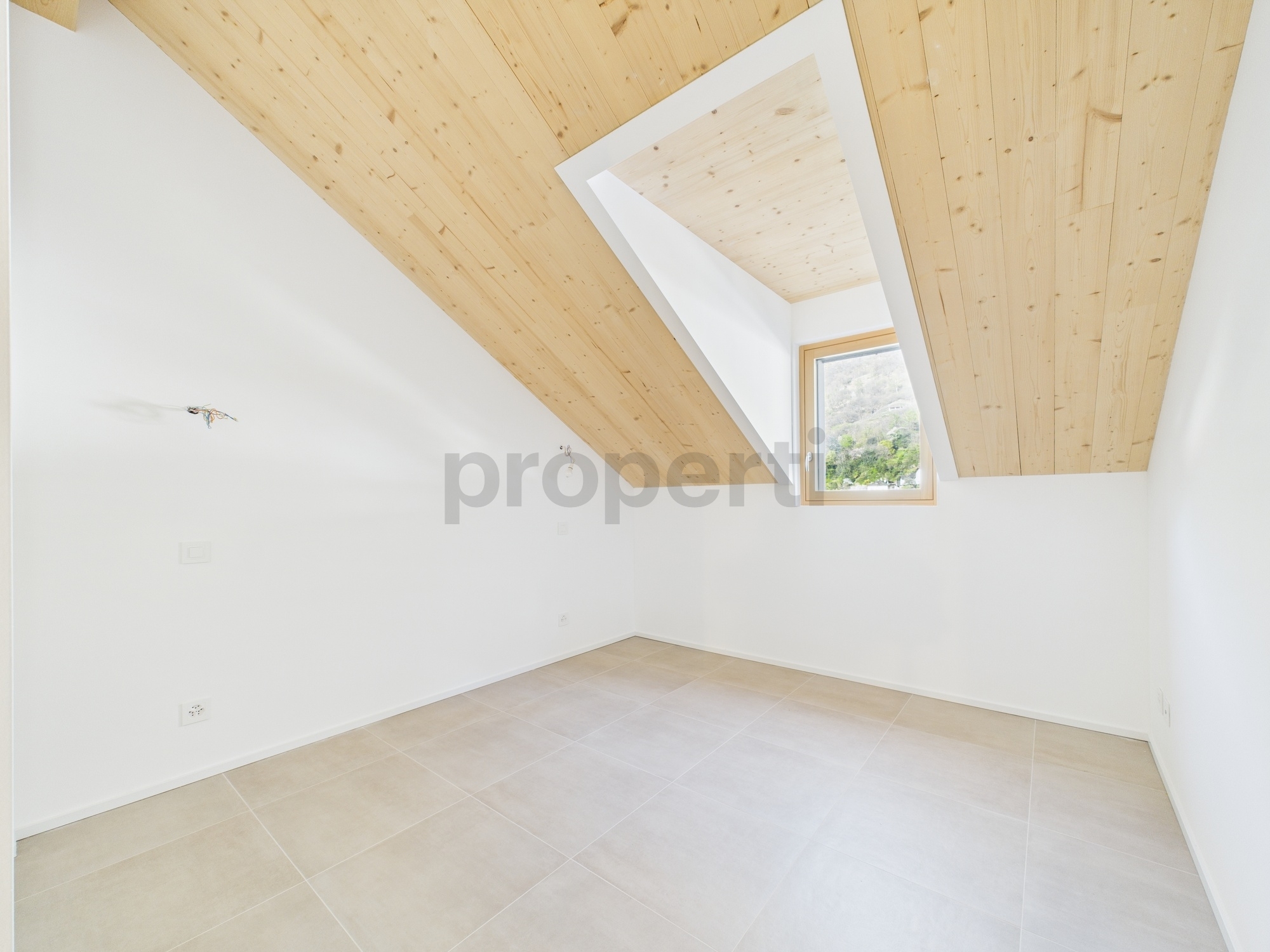 Heller leerer Dachraum mit Holzdecke und Fliesenboden