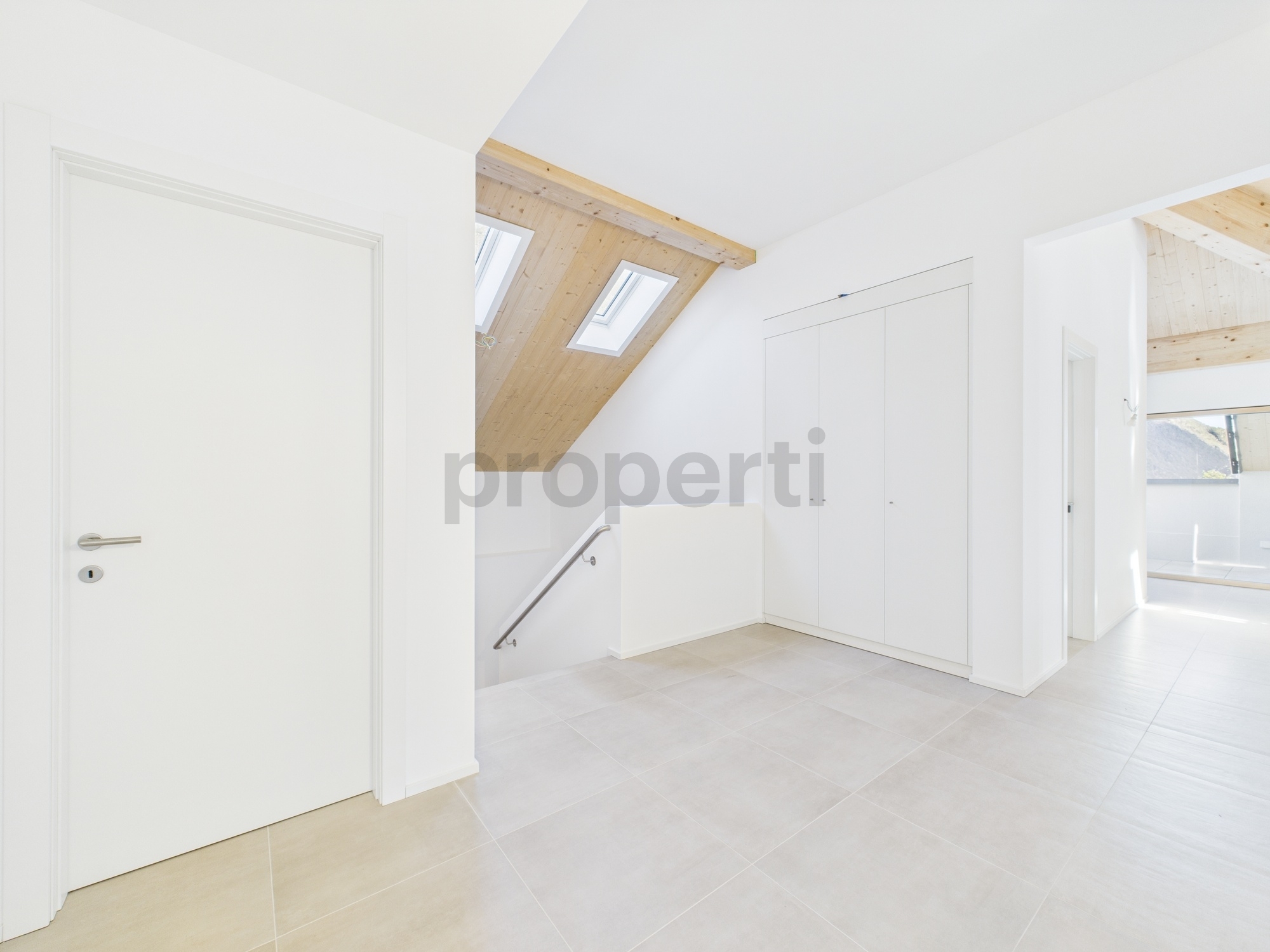 Heller Dachgeschoss-Flur mit Treppe und Einbauschrank