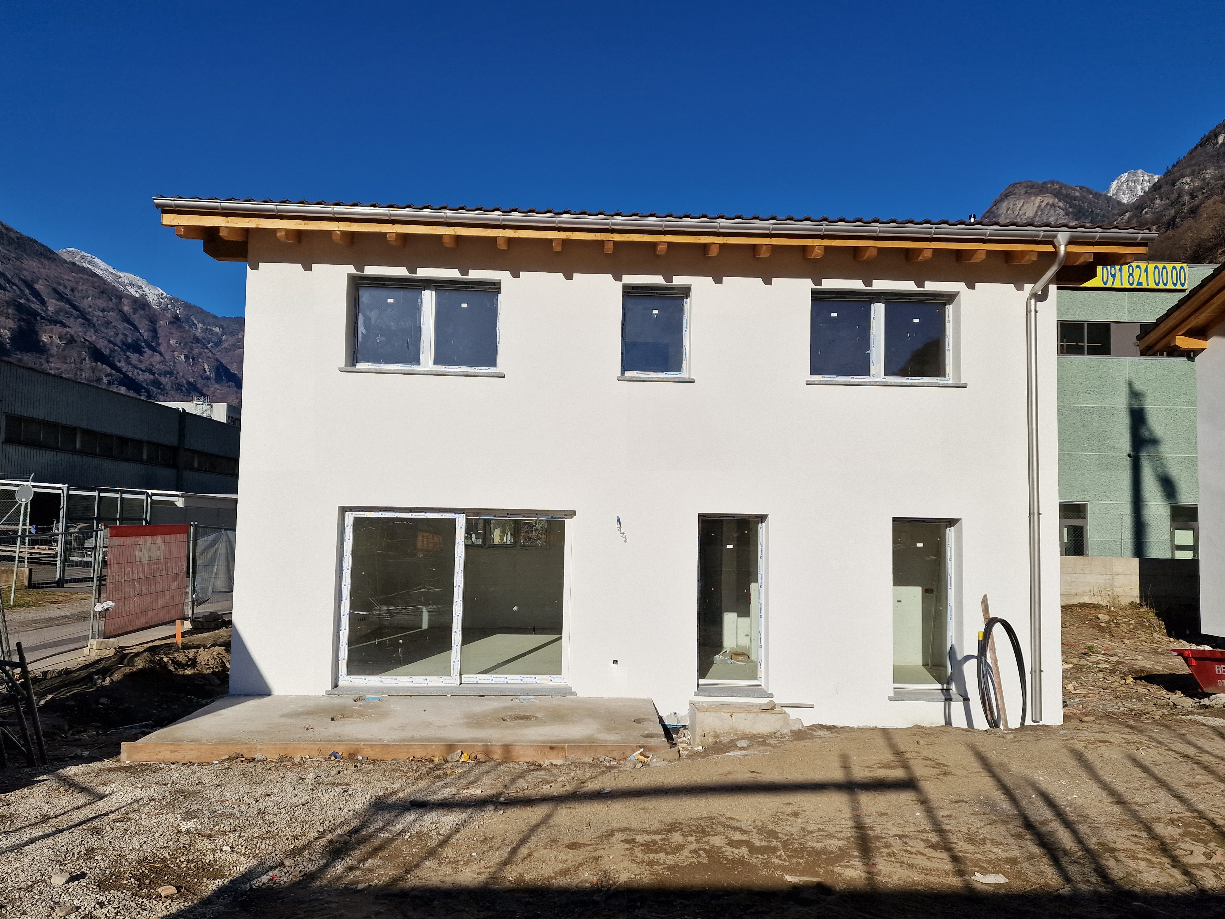 Neubau-Außenansicht mit Bergkulisse