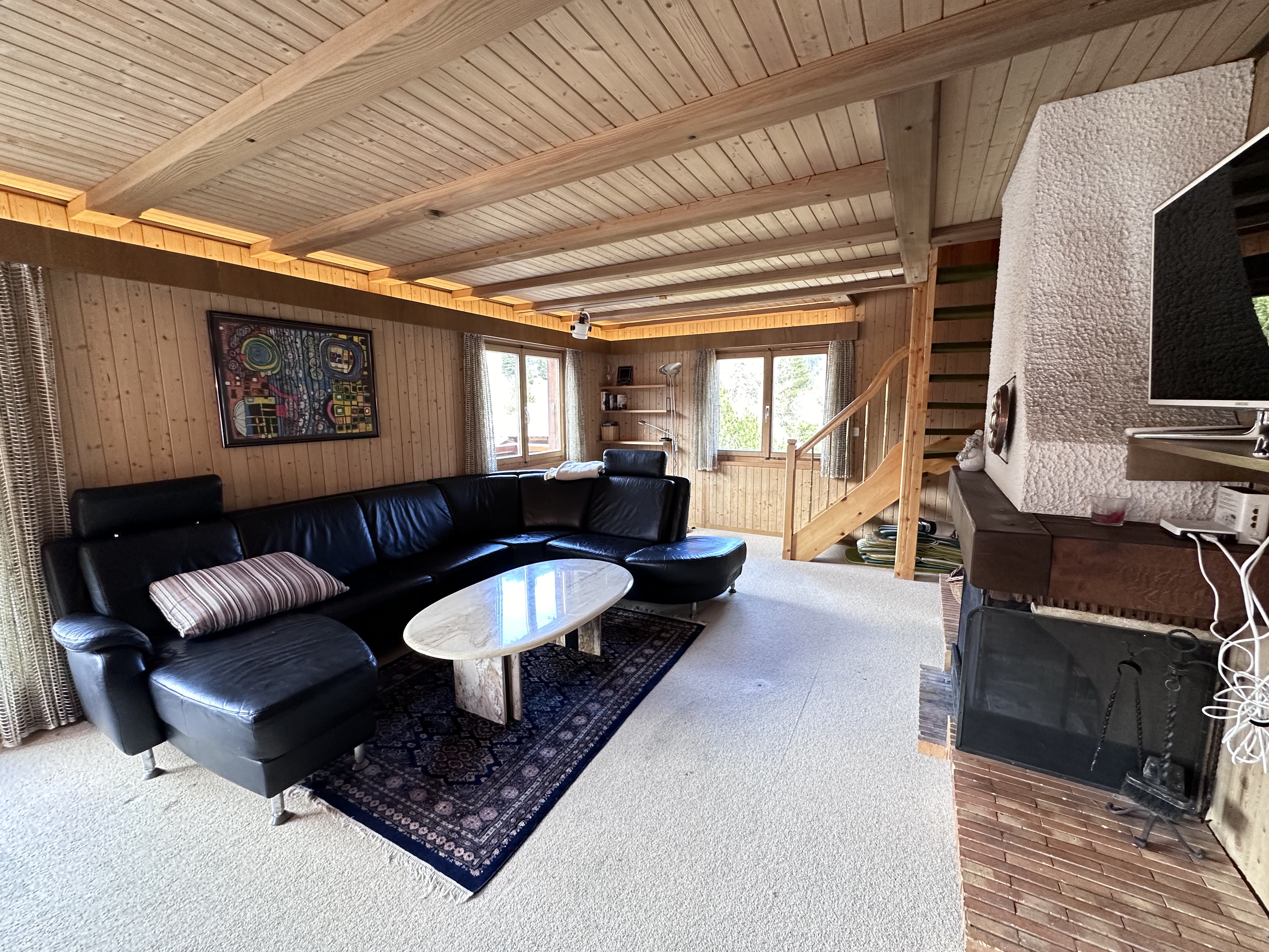 Gemütliches Wohnzimmer mit Kamin und Holzdecke