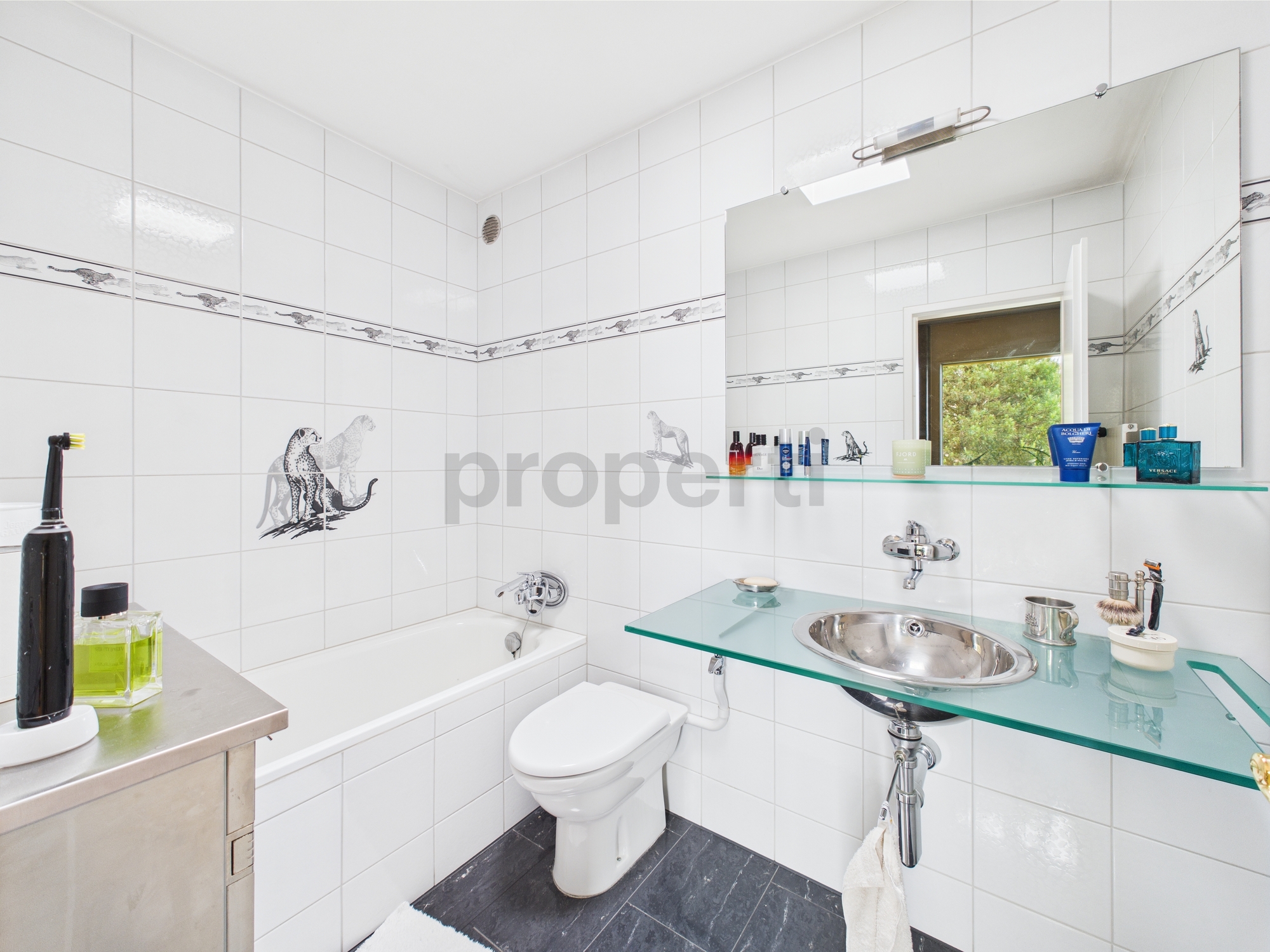 Modernes Badezimmer mit weißer Fliesenoptik und Glaswaschtisch