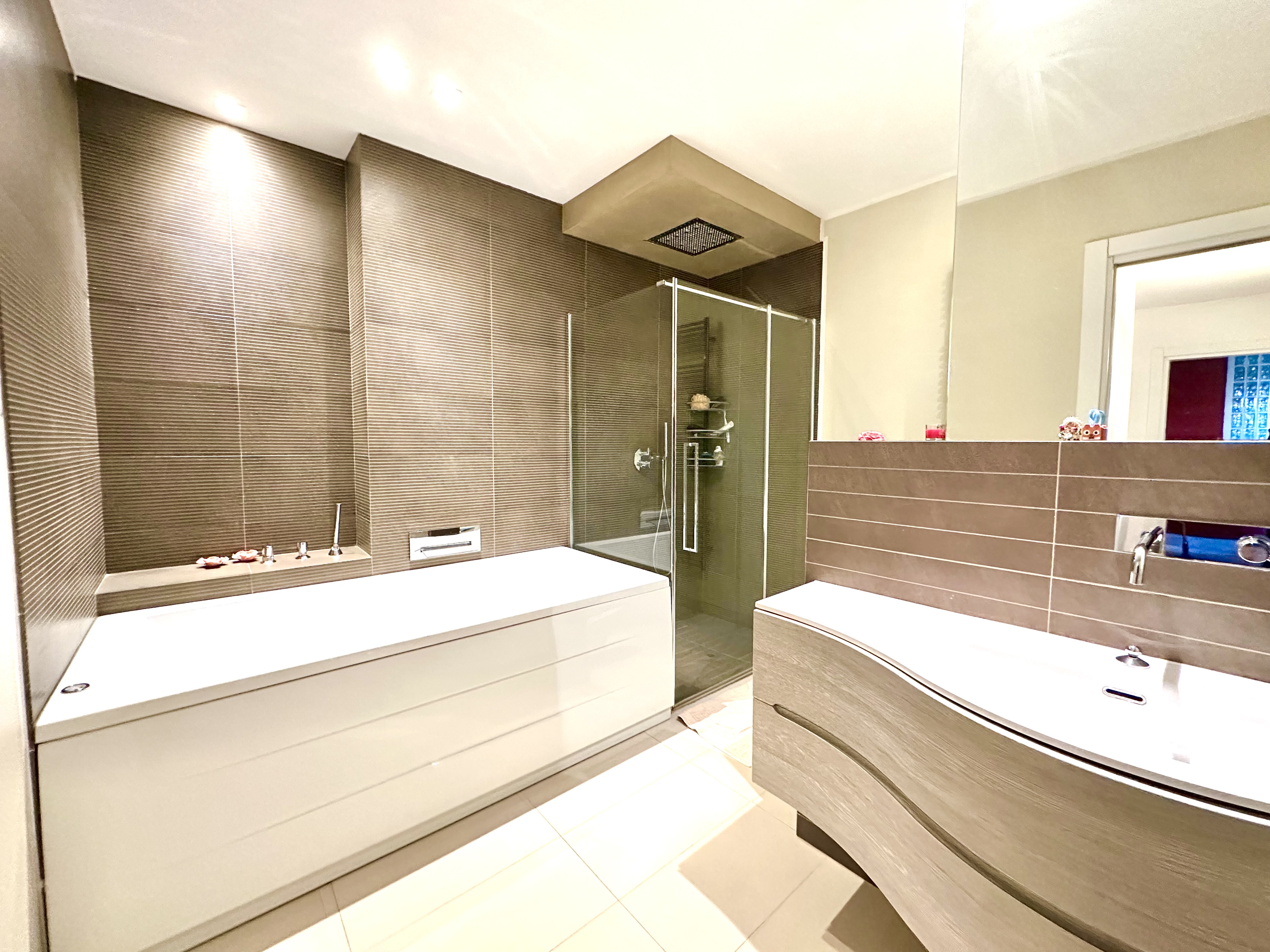 Modernes Badezimmer mit Badewanne und Glasdusche