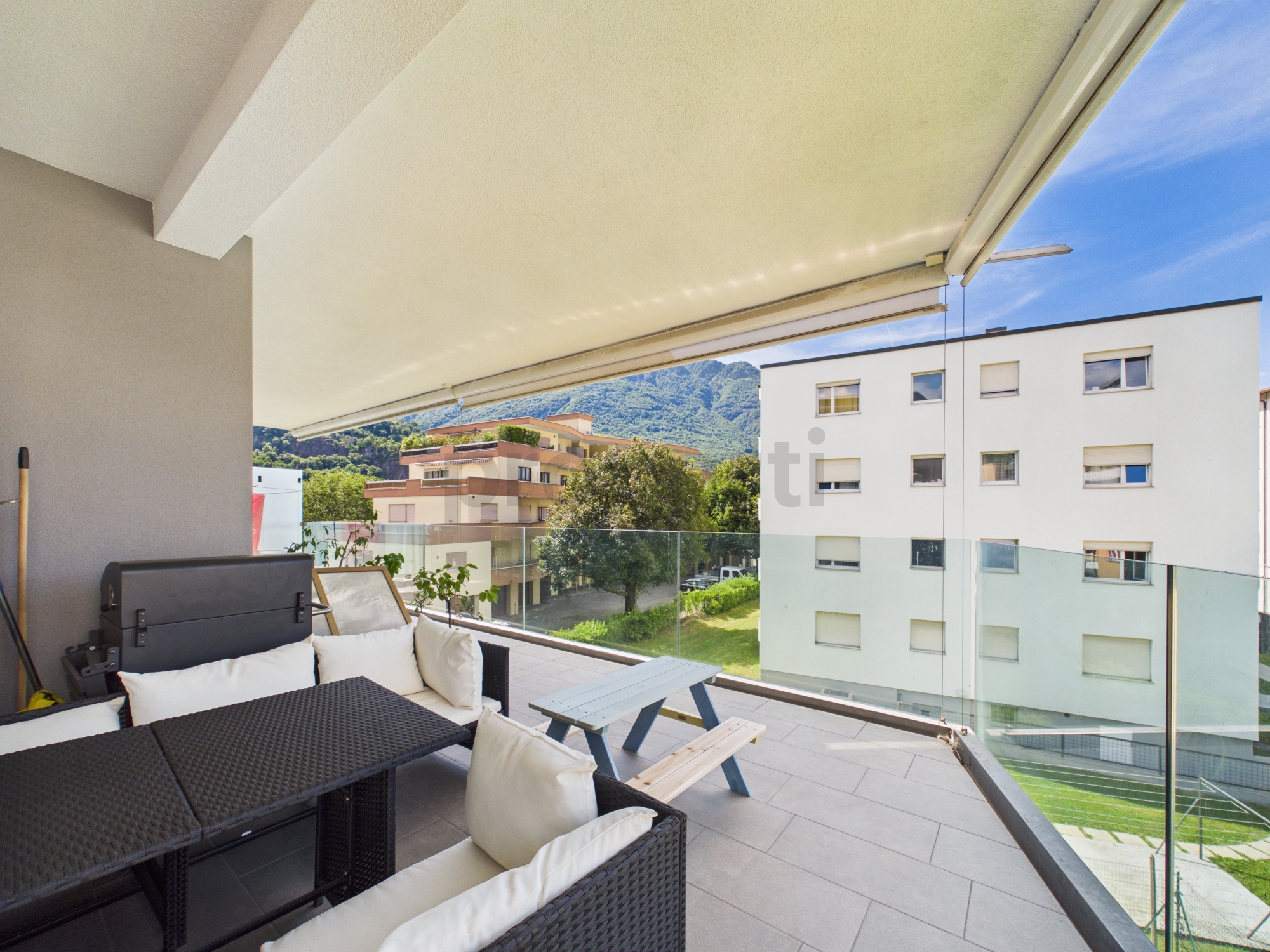 Überdachter Balkon mit Sitzgruppe und Bergblick