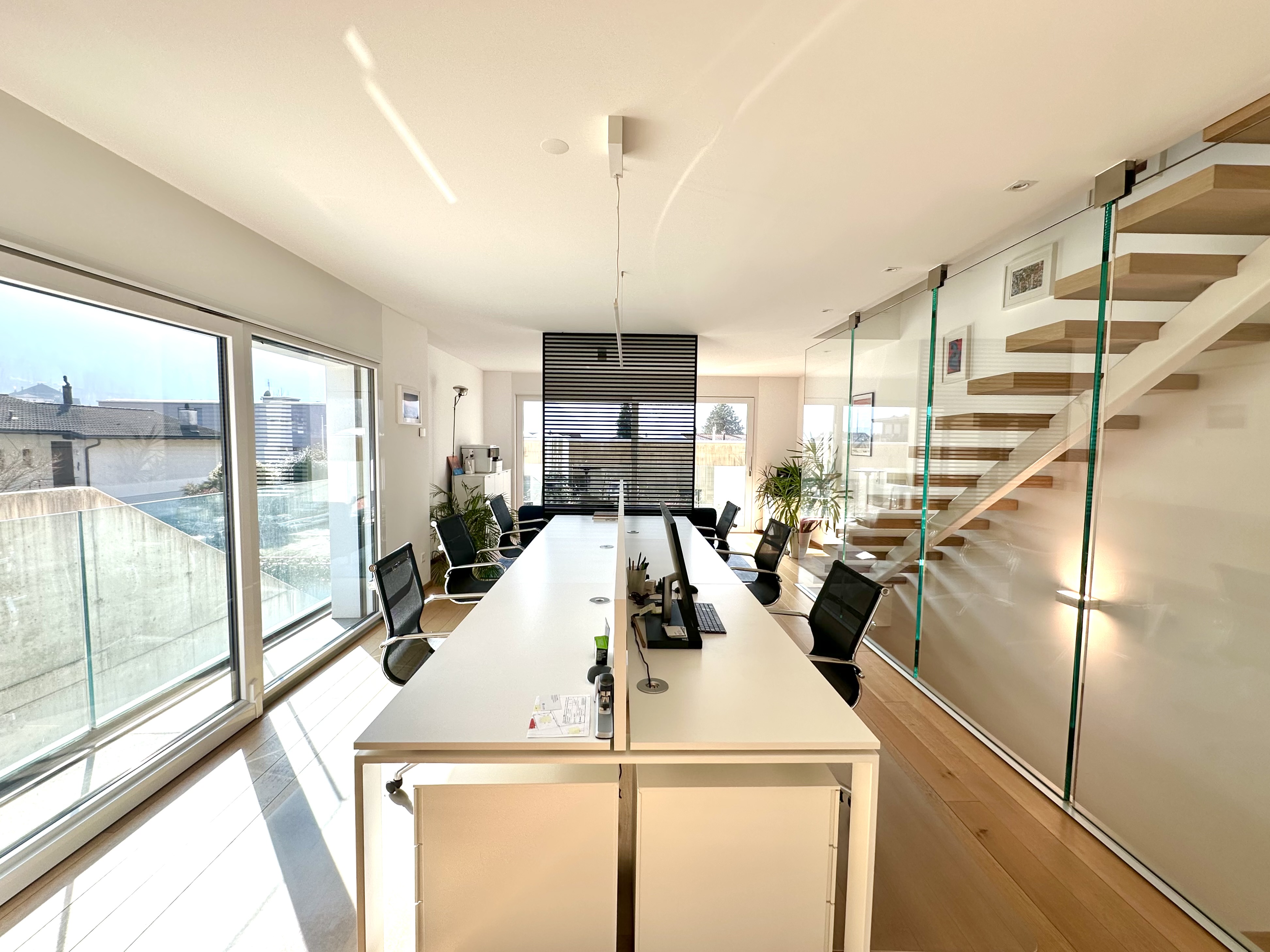 Modernes Büro- oder Besprechungszimmer mit Glaswand und Treppe