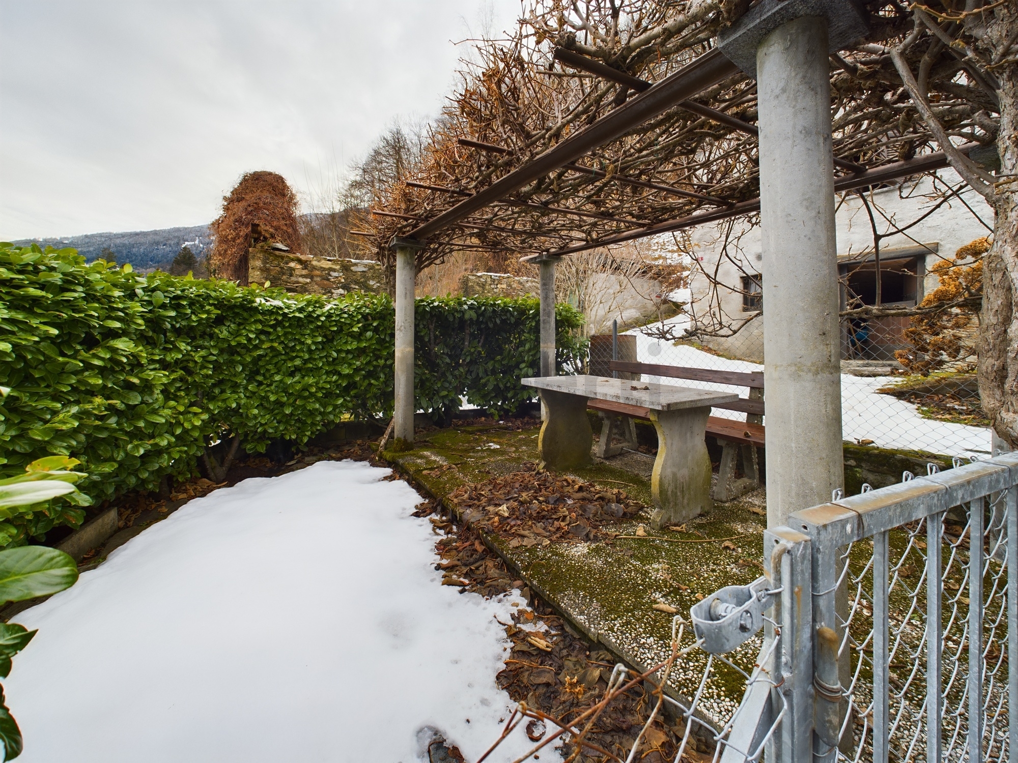 Winterlicher Außenbereich mit Pergola und Sitzplatz