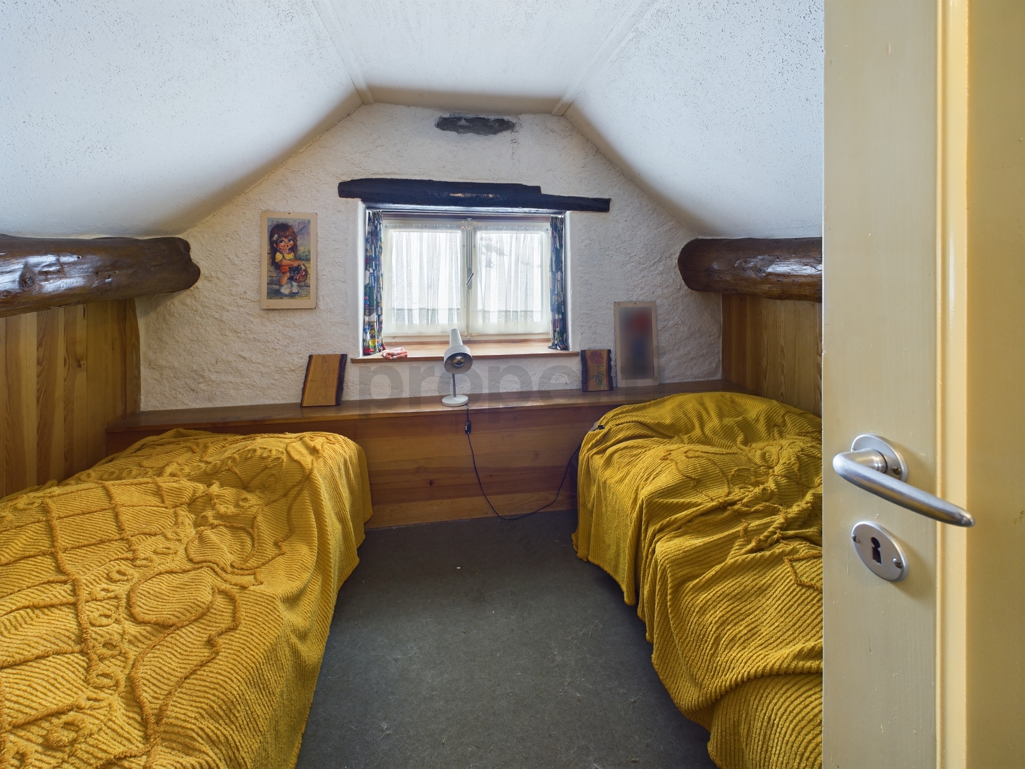 Kleines Schlafzimmer mit zwei Betten und Fenster