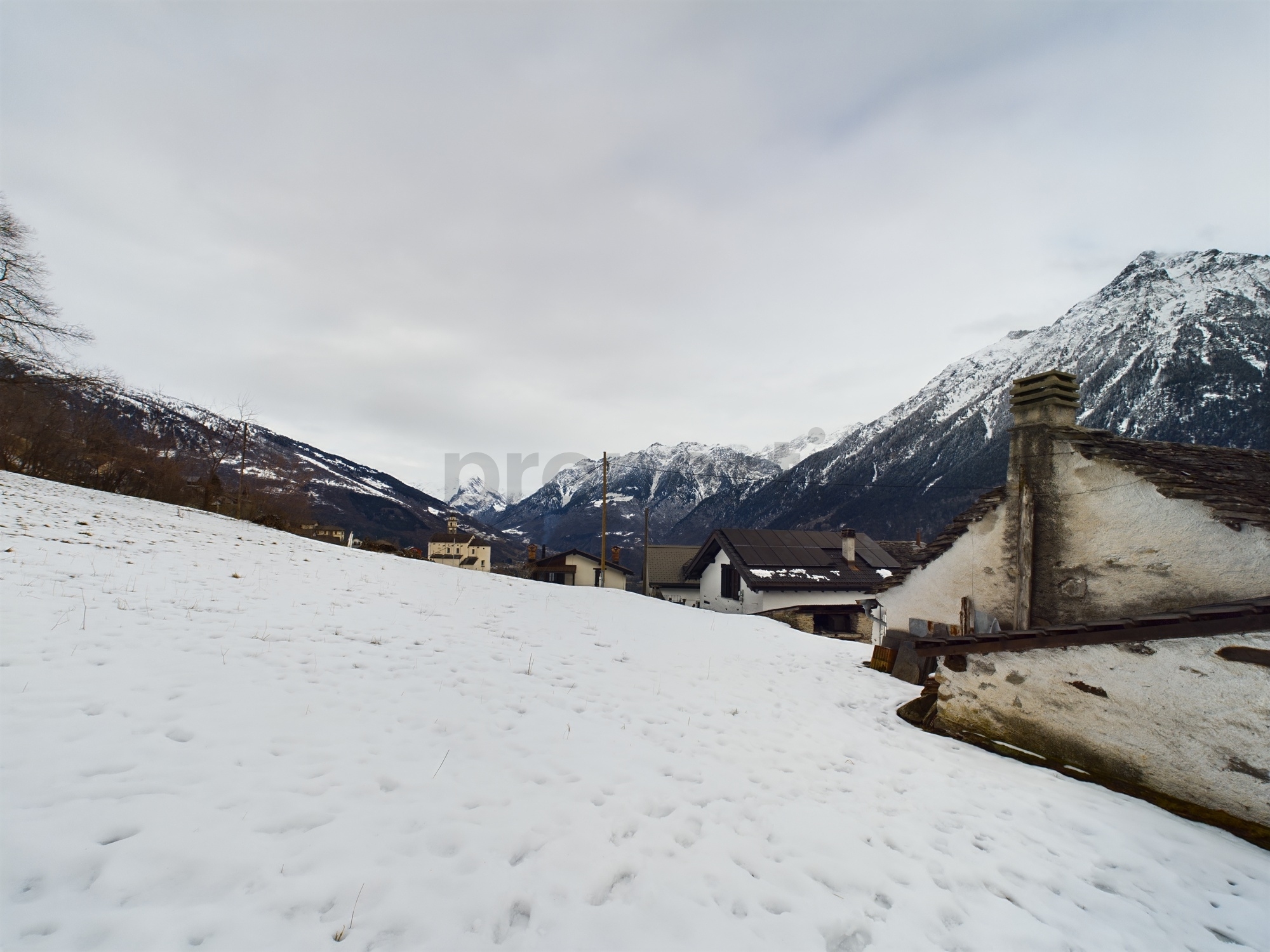 Winterliche Alpenlandschaft mit Dorf und verschneitem Tal