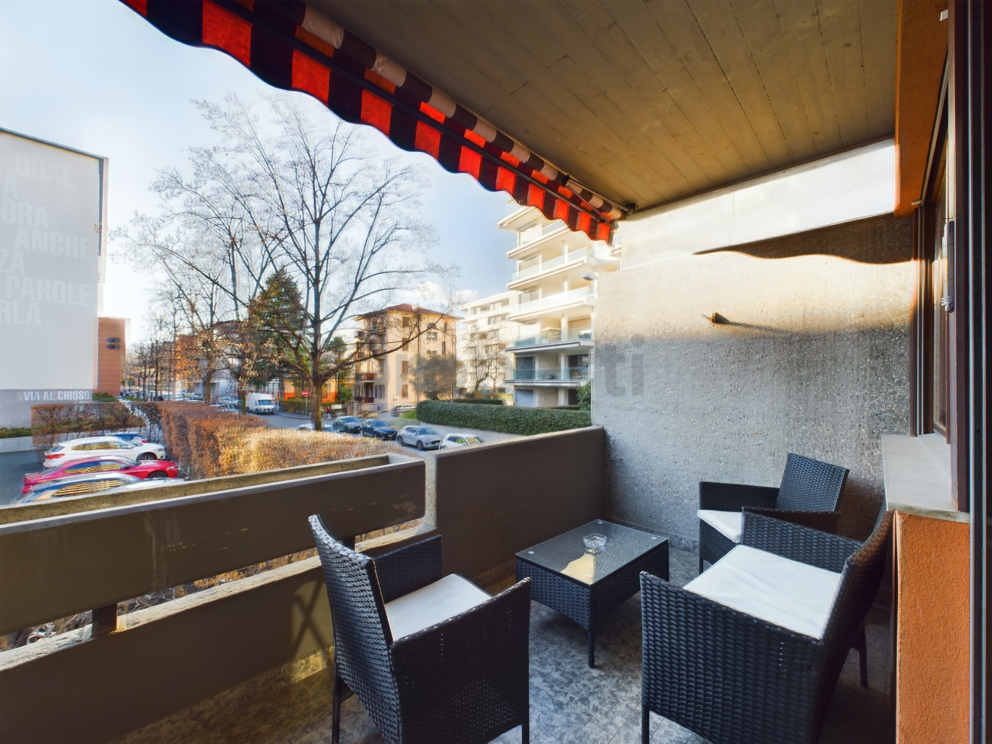 Überdachter Balkon mit Sitzgruppe und Straßenblick