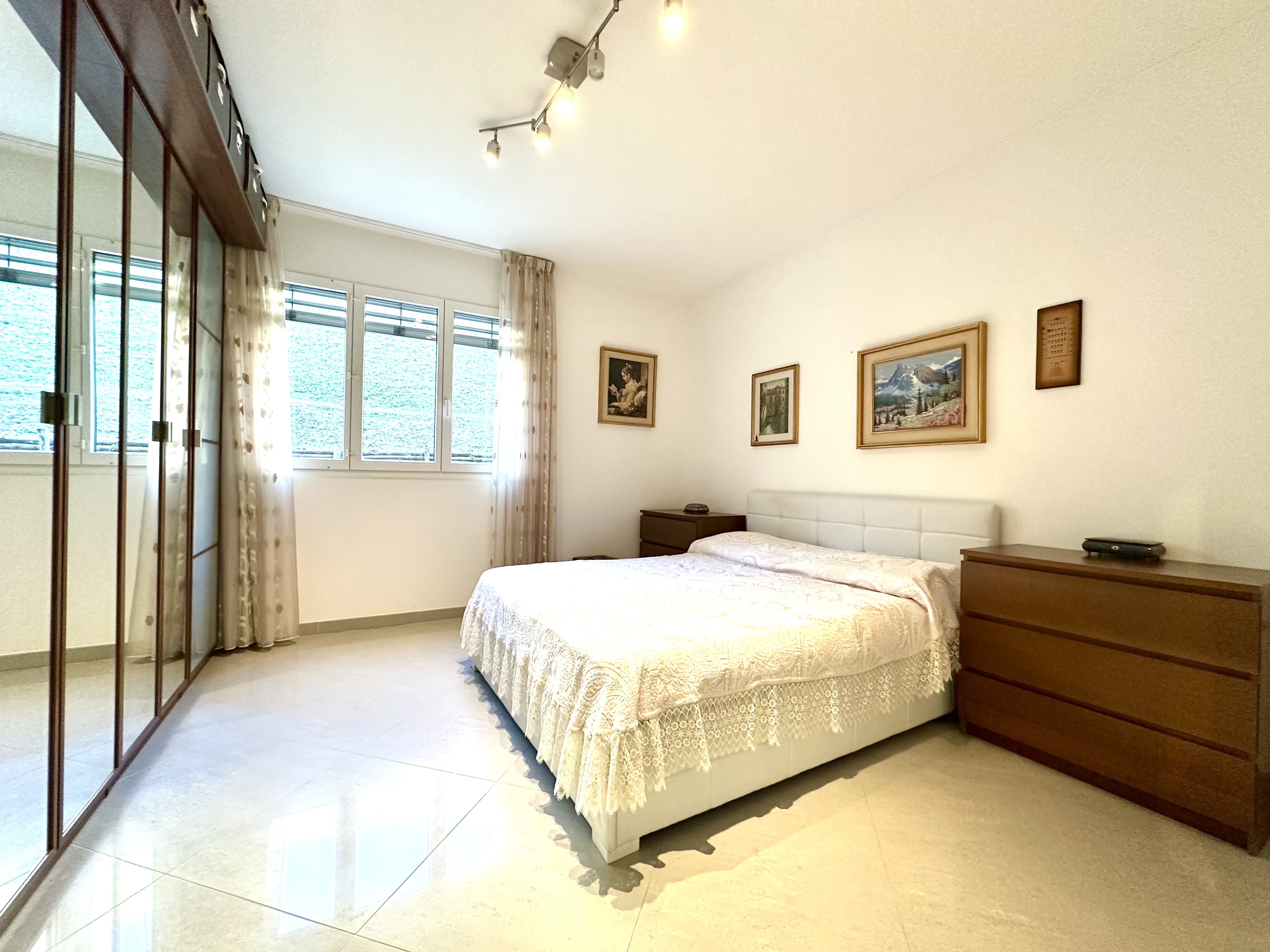 Helles Schlafzimmer mit Einbauschrank und großem Fenster