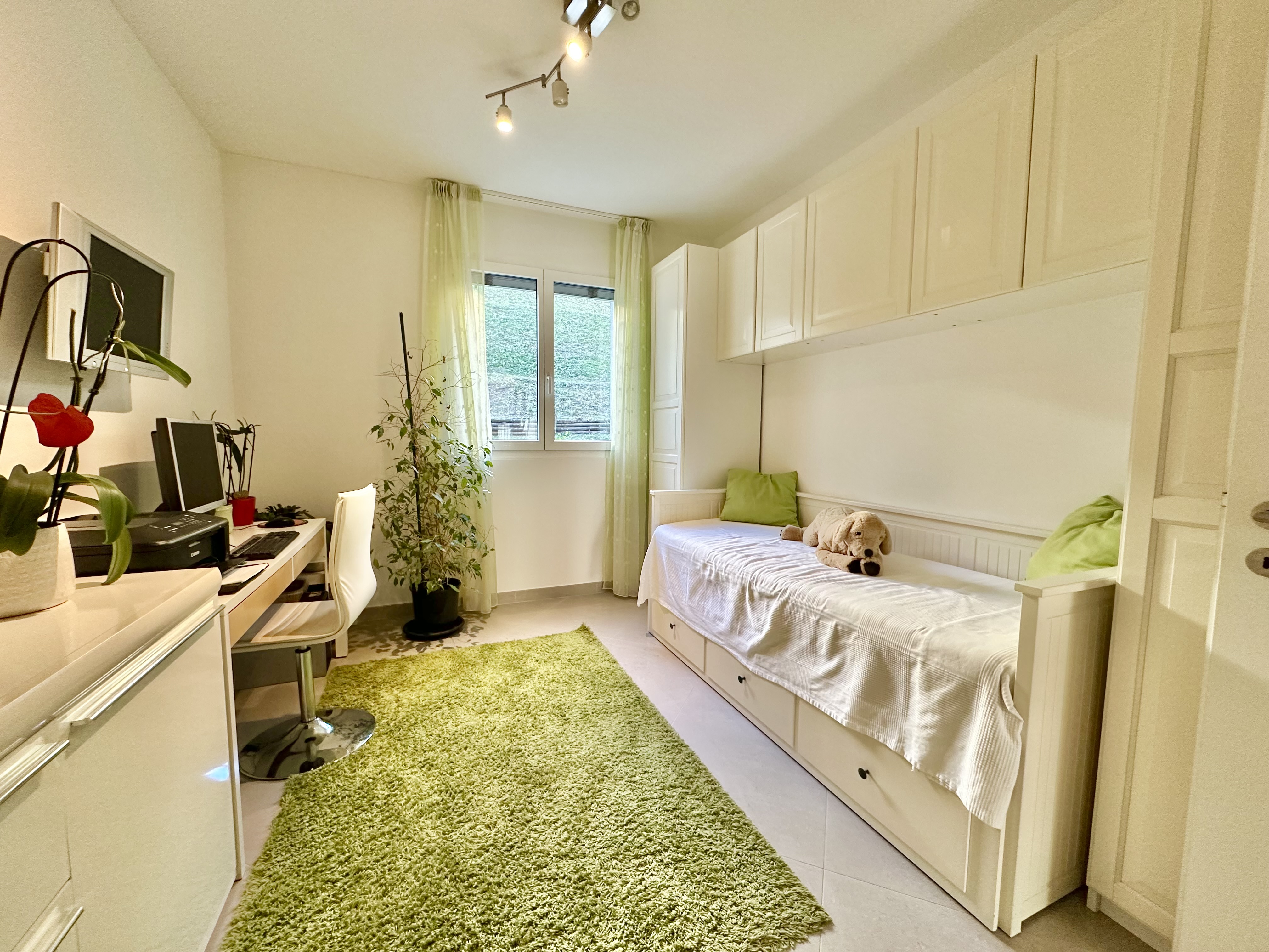 Helles, schmal geschnittenes Schlafzimmer mit Arbeitsbereich
