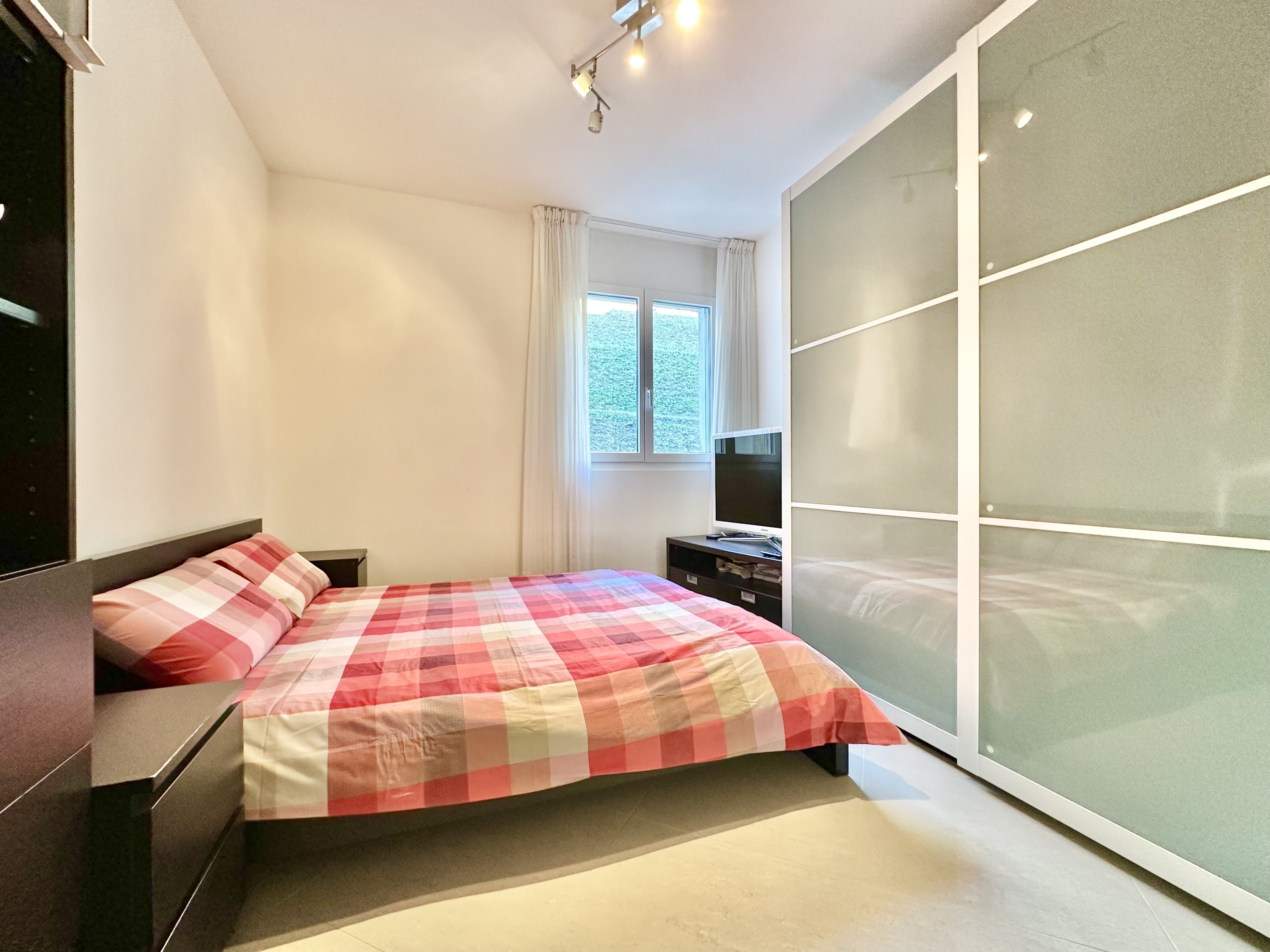 Helles Schlafzimmer mit modernem Schrank und Bett